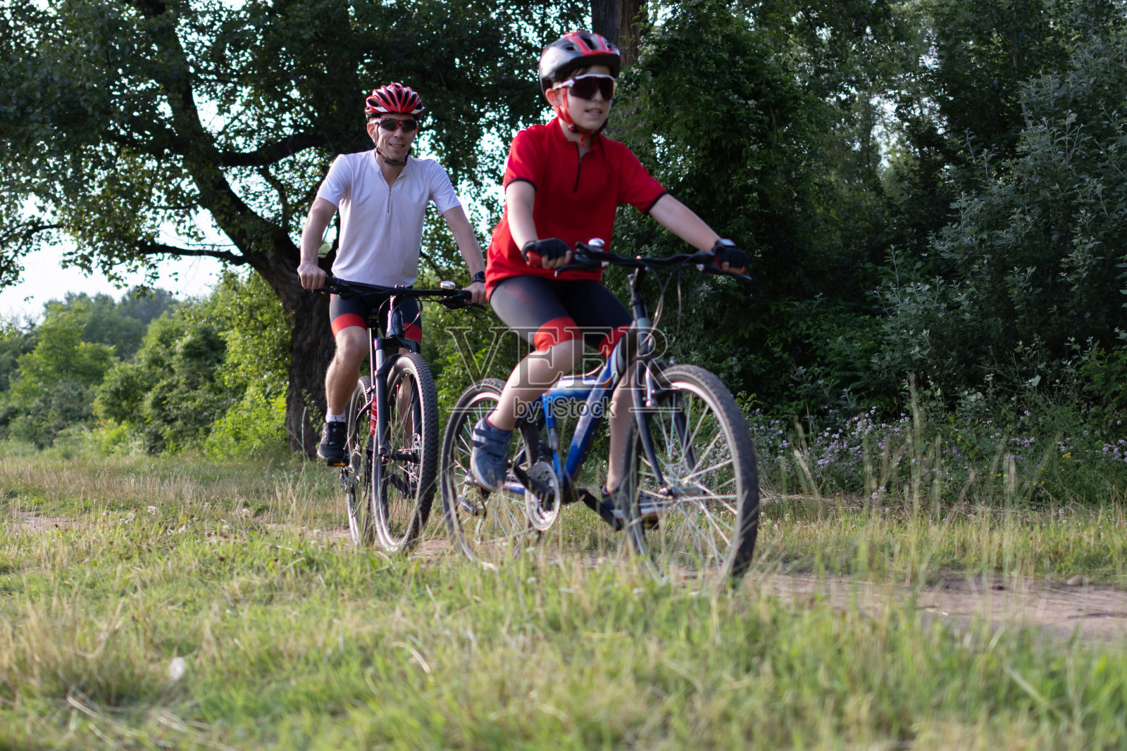 父子俩在自行车道上骑自行车。健康的家庭生活方式照片摄影图片