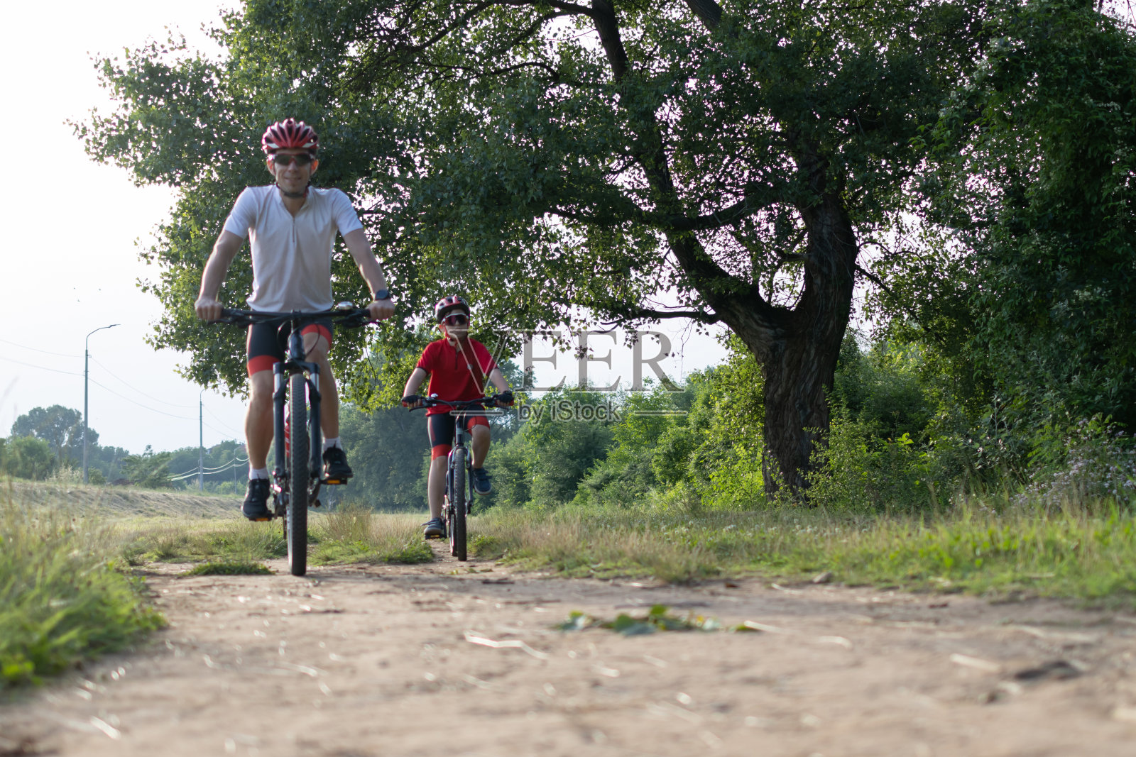 父子俩在自行车道上骑自行车。健康的家庭生活方式照片摄影图片