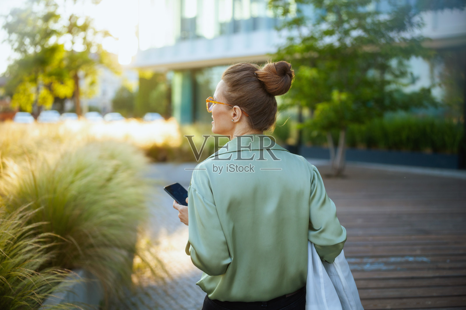 从背后看到一位女商人在商务中心附近使用电话照片摄影图片