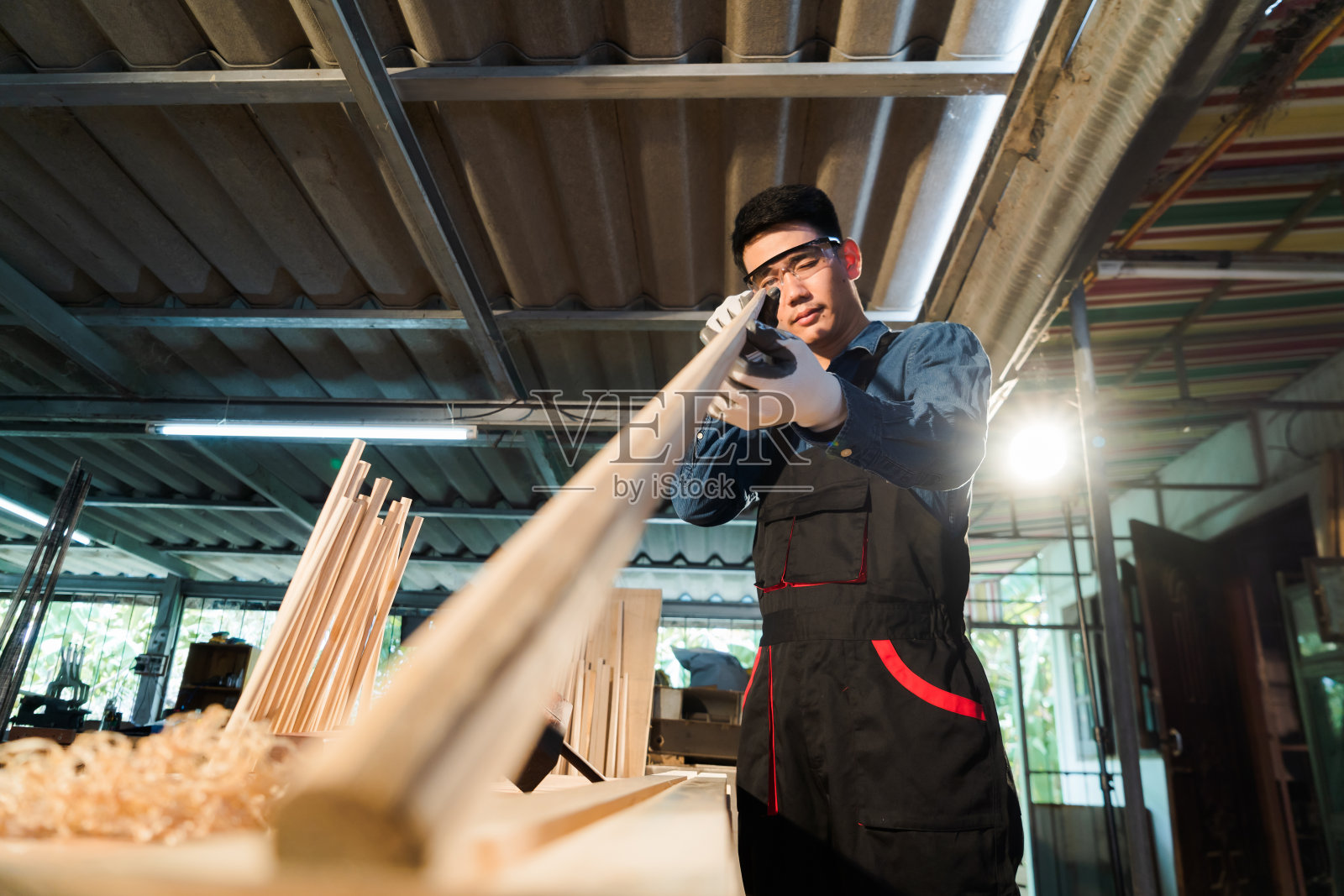 在车间里，木匠的手正在小心翼翼地瞄准木头，制作高强度的手工斯诺克球杆。照片摄影图片
