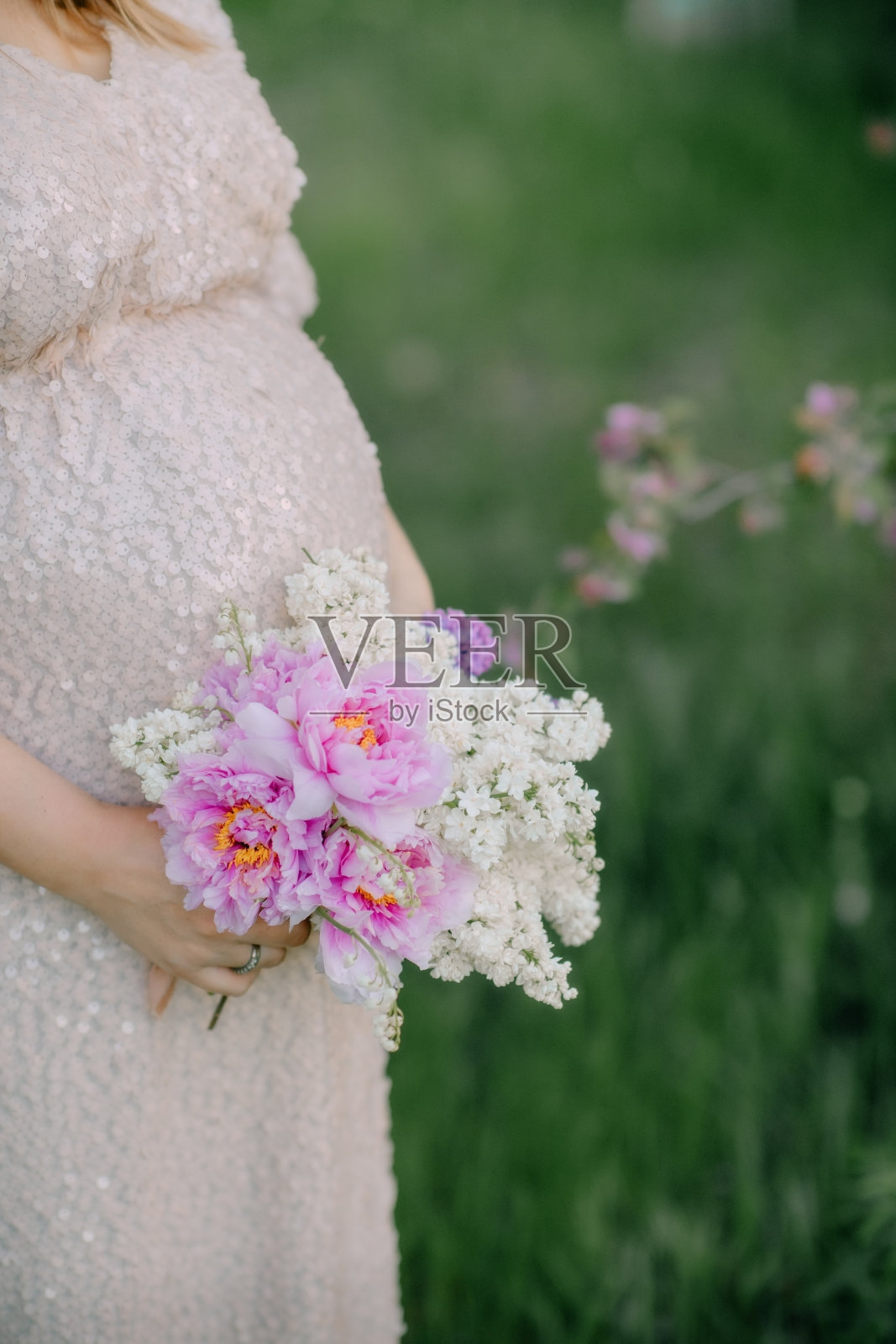 一个穿着长裙抱着肚子的孕妇照片摄影图片