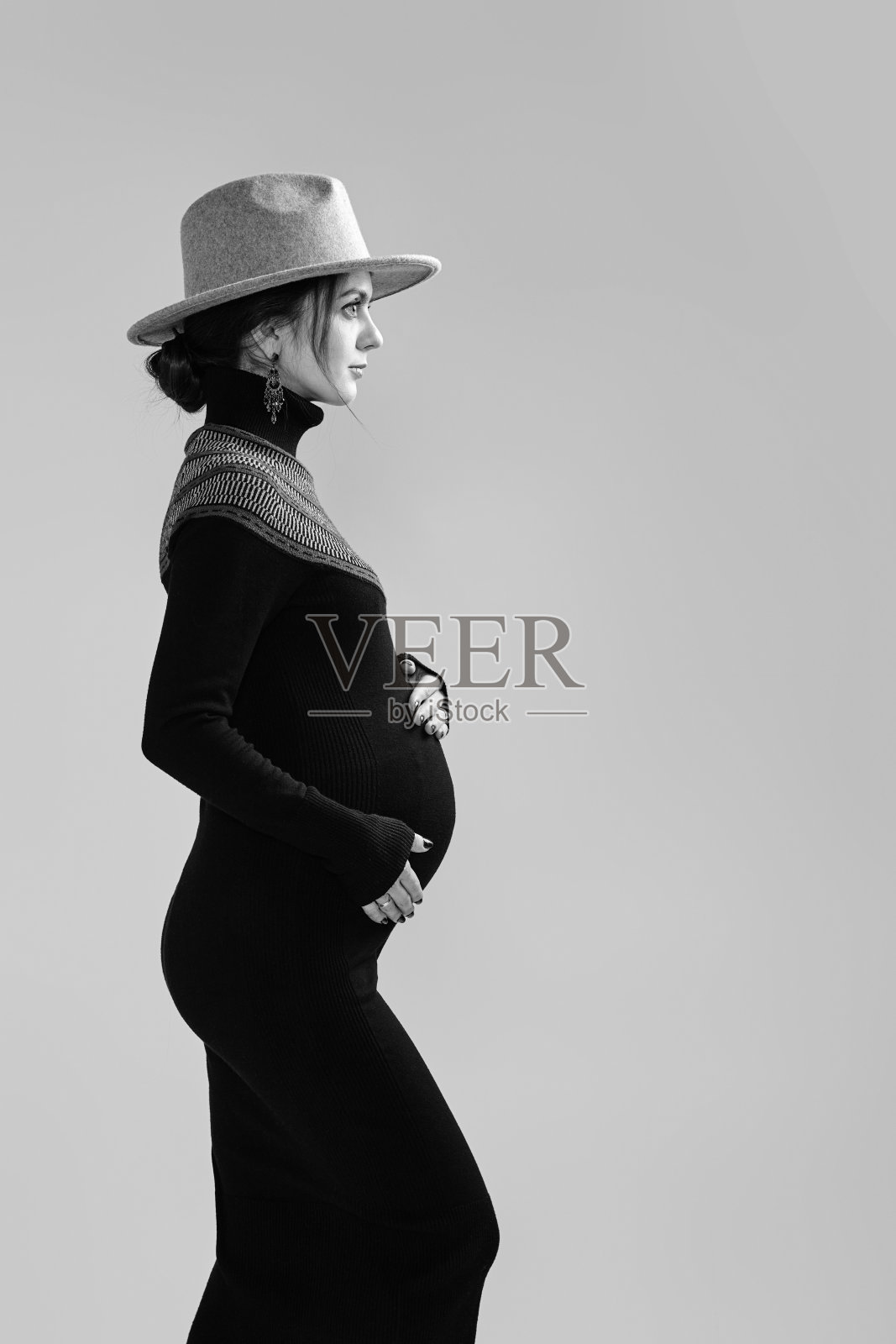 穿着裙子抱着肚子的漂亮孕妇照片摄影图片