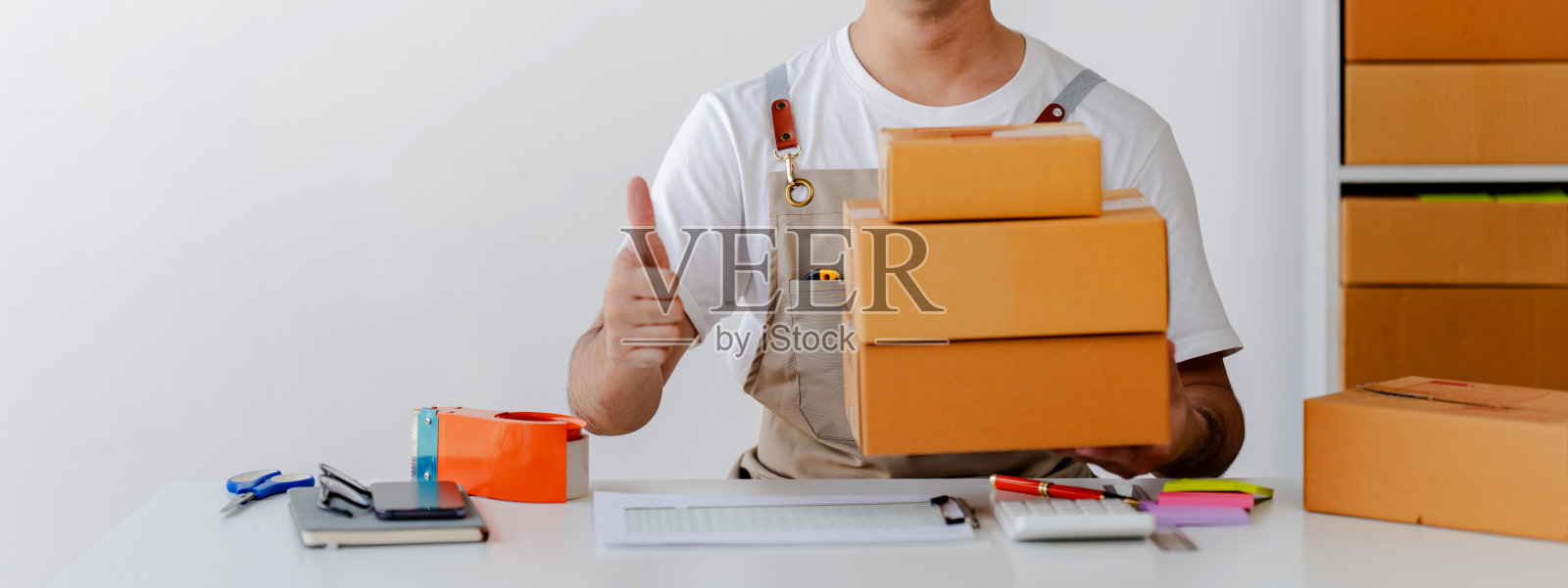 中小企业创业小男，在工作中检查包裹，自由职业者，推销员，检查生产订单，包装产品交付给客户，中小企业概念照片摄影图片