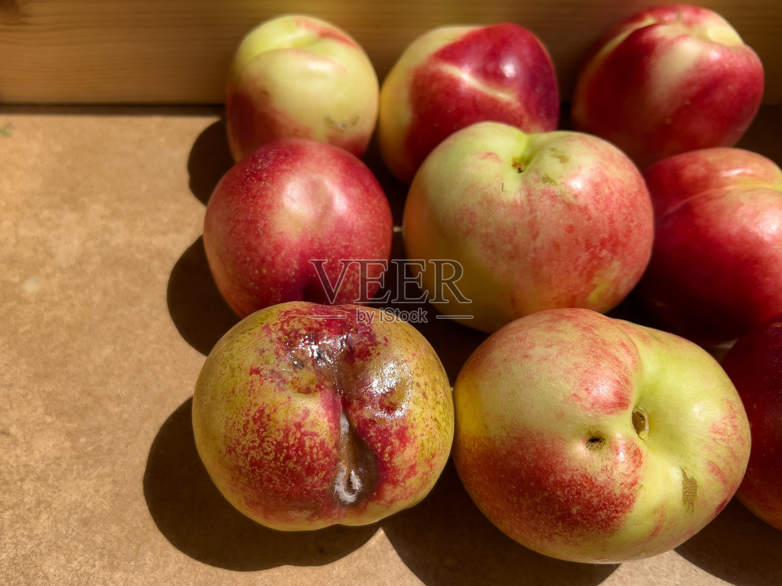 木盒里的油桃。变质过熟油桃的背景正常照片摄影图片