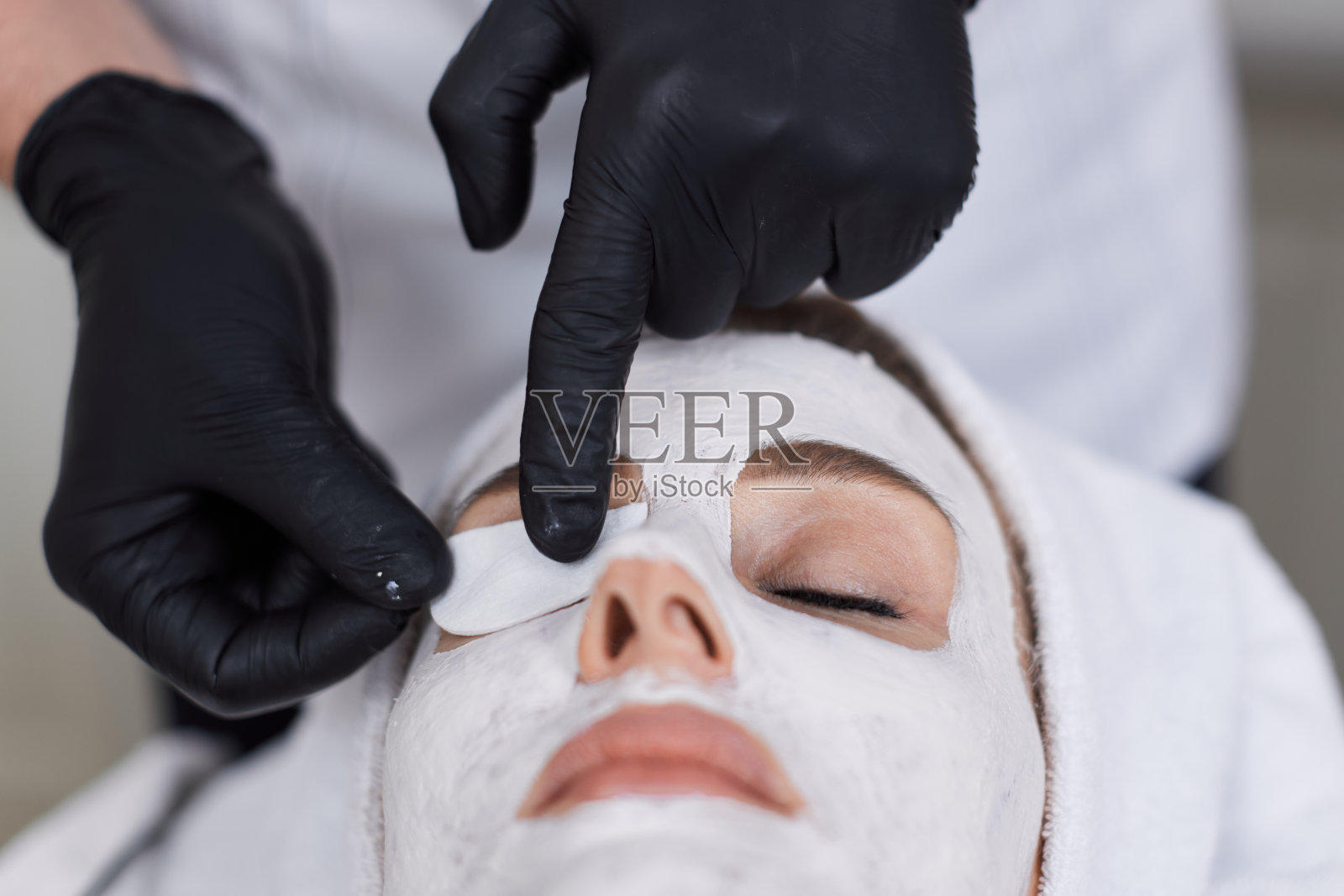 美容师在水疗沙龙给女士敷面膜。皮肤护理照片摄影图片