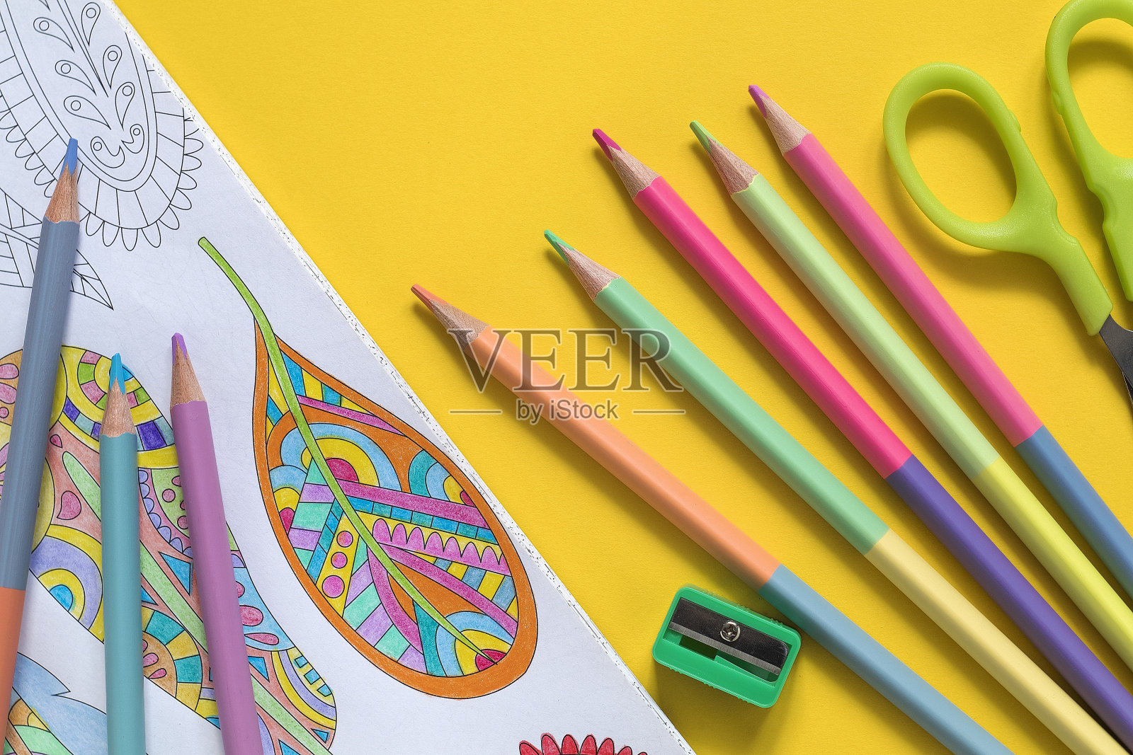 抗压力着色书和粉彩两面铅笔在一个黄色的背景。艺术治疗。照片摄影图片