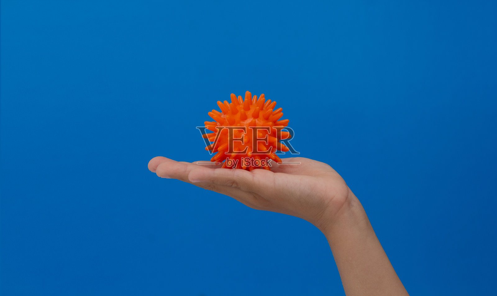 尖尖的橙色按摩针球在孩子的手掌照片摄影图片