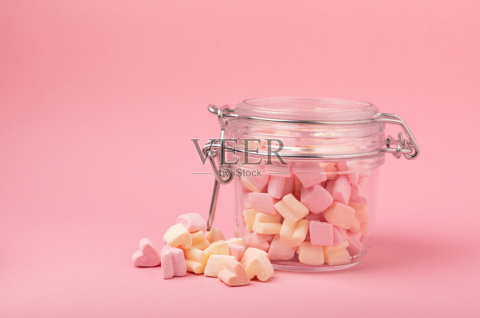 粉红色背景的棉花糖放在玻璃碗里白色的棉花糖平铺甜食和零食当零食