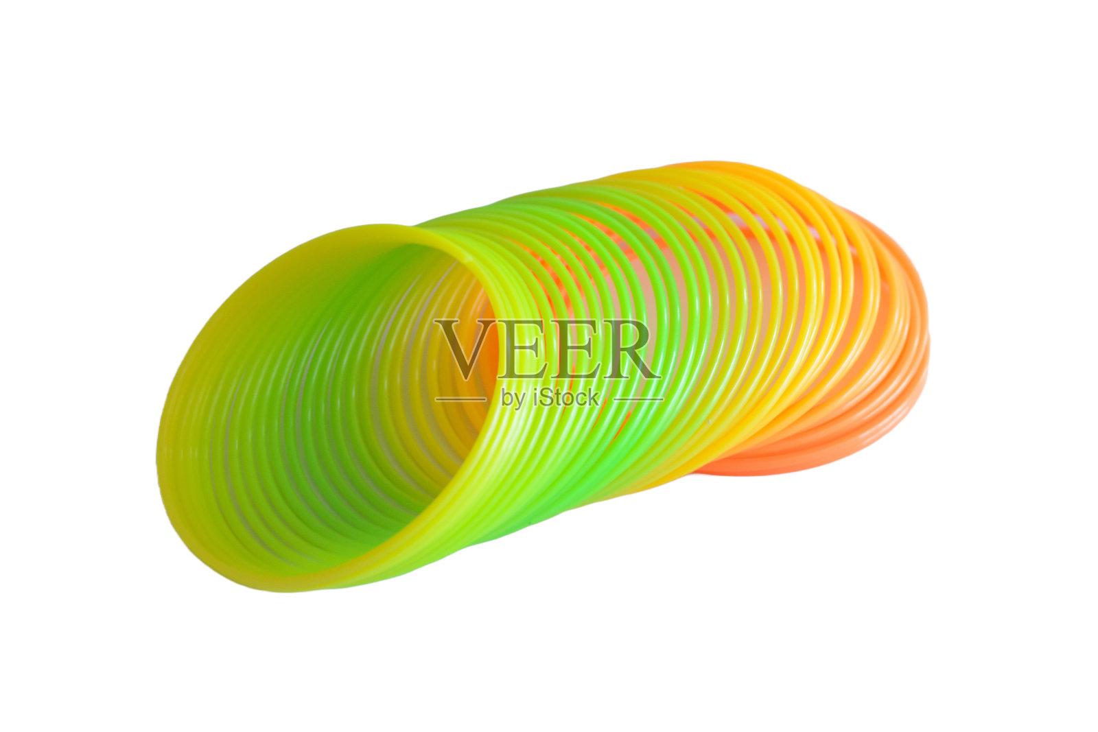 弹簧玩具彩色塑料折叠彩虹圈孤立的白色背景。照片摄影图片