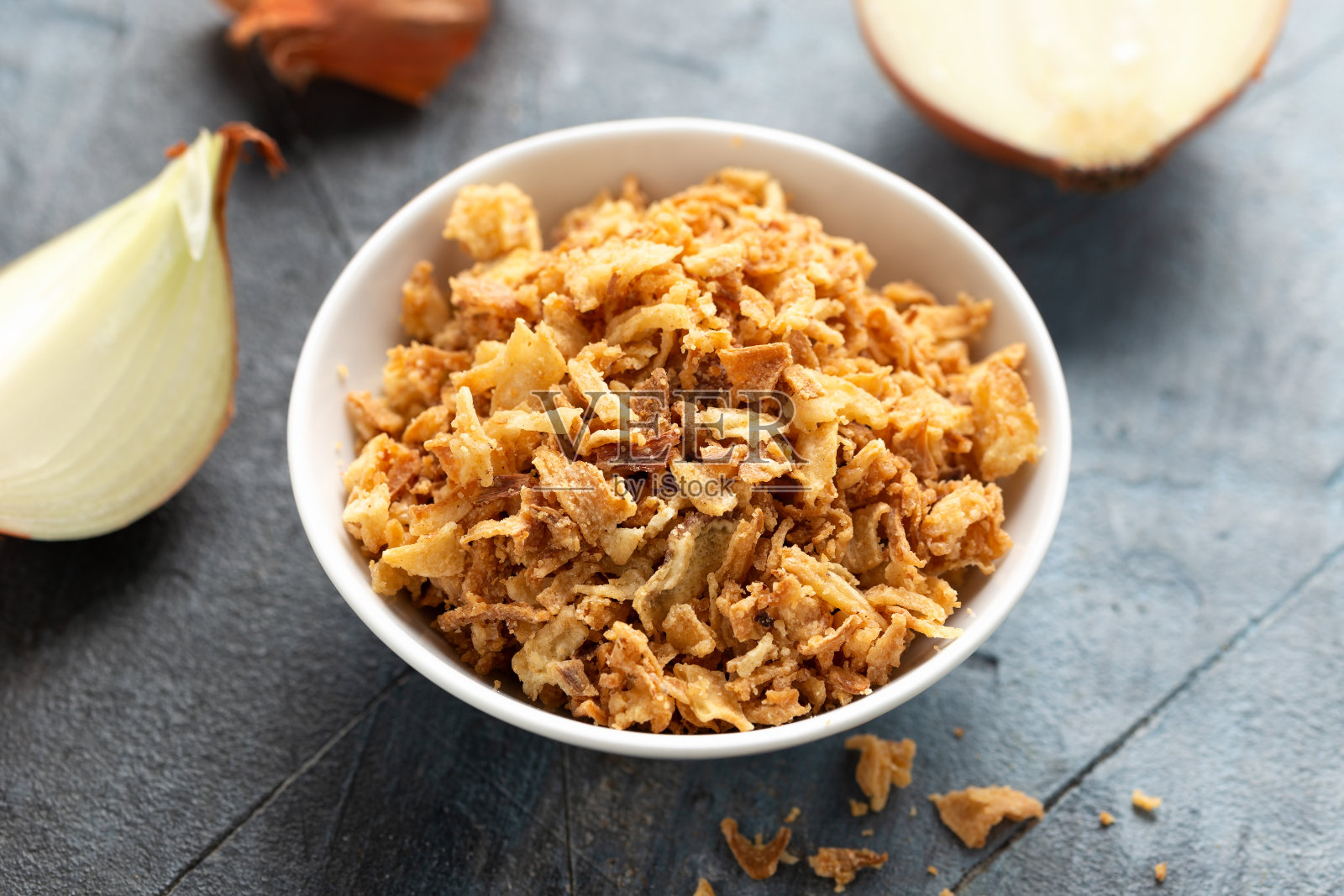 白碗脆炸洋葱片。照片摄影图片