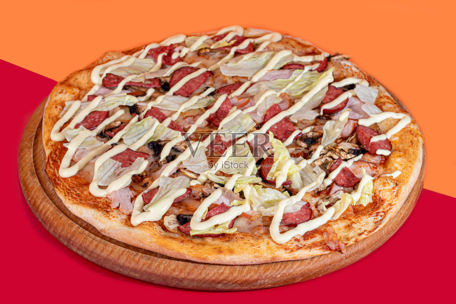 用木制盘子盛上培根芝士和香草披萨，配上芝士和圣女果。在彩色背景上。照片摄影图片