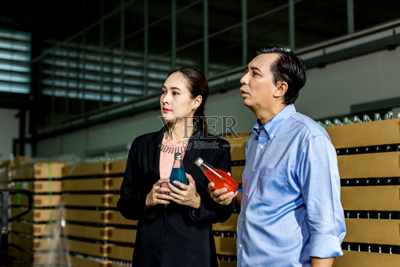 顾客参观仓库或工厂以作出购买决定。业主向客户解释产品。检验进出口货物质量。饮料厂饮料生产线照片摄影图片