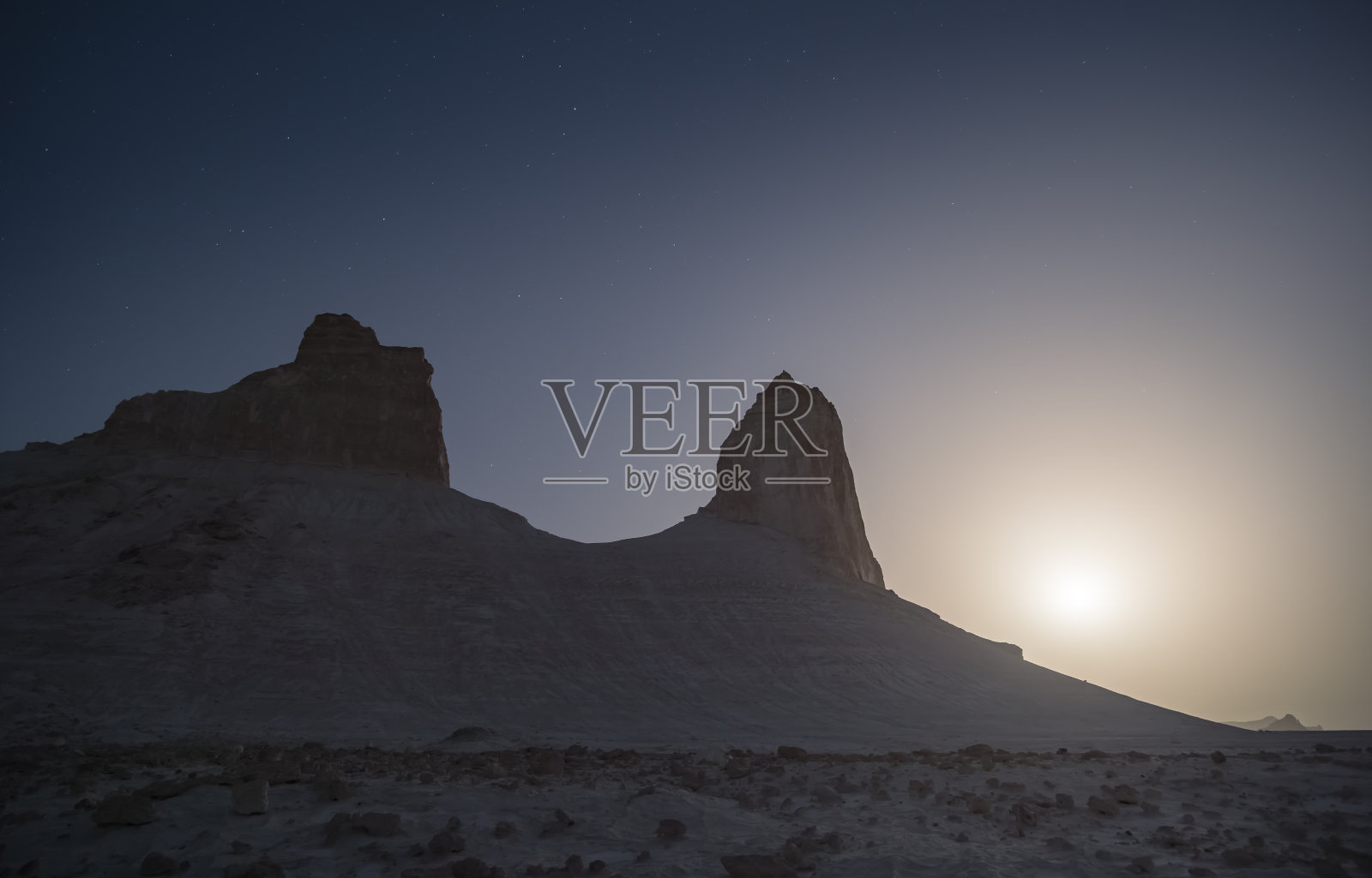 白垩和石灰岩的残余物在夜晚的哈萨克草原上以星空和月亮为背景，在沙漠中风化后形成的垂直地貌照片摄影图片