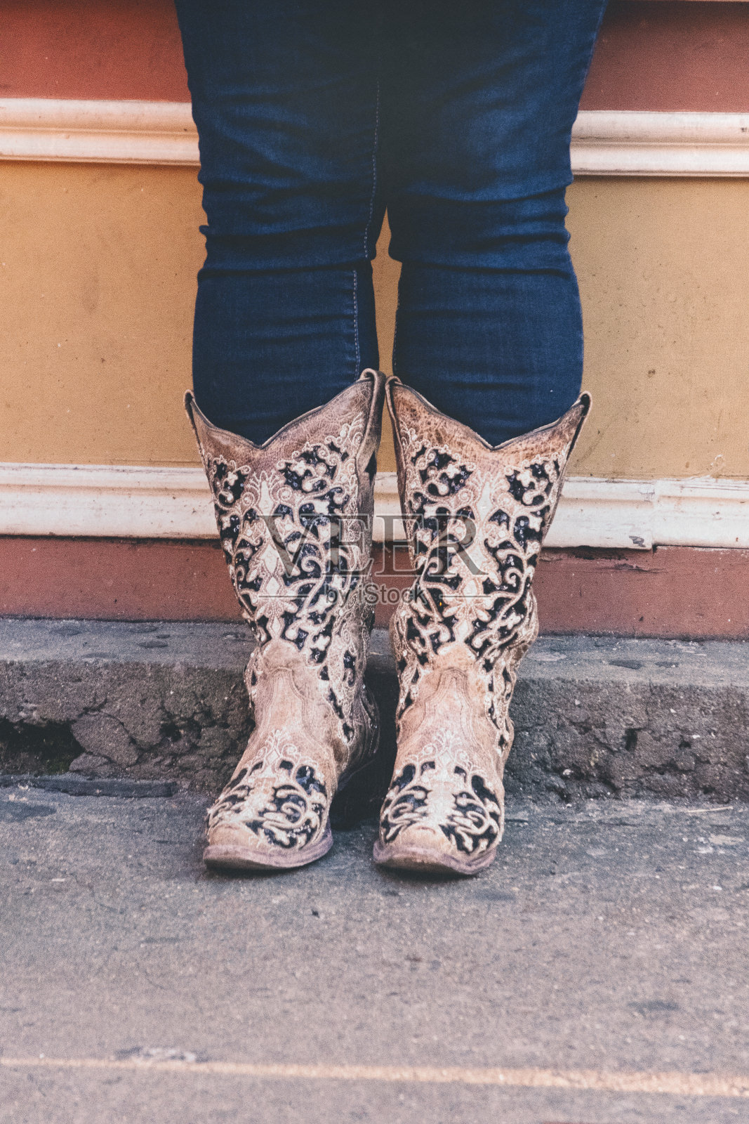 在田纳西州纳什维尔市中心，一名女子穿着牛仔靴站在那里等待照片摄影图片