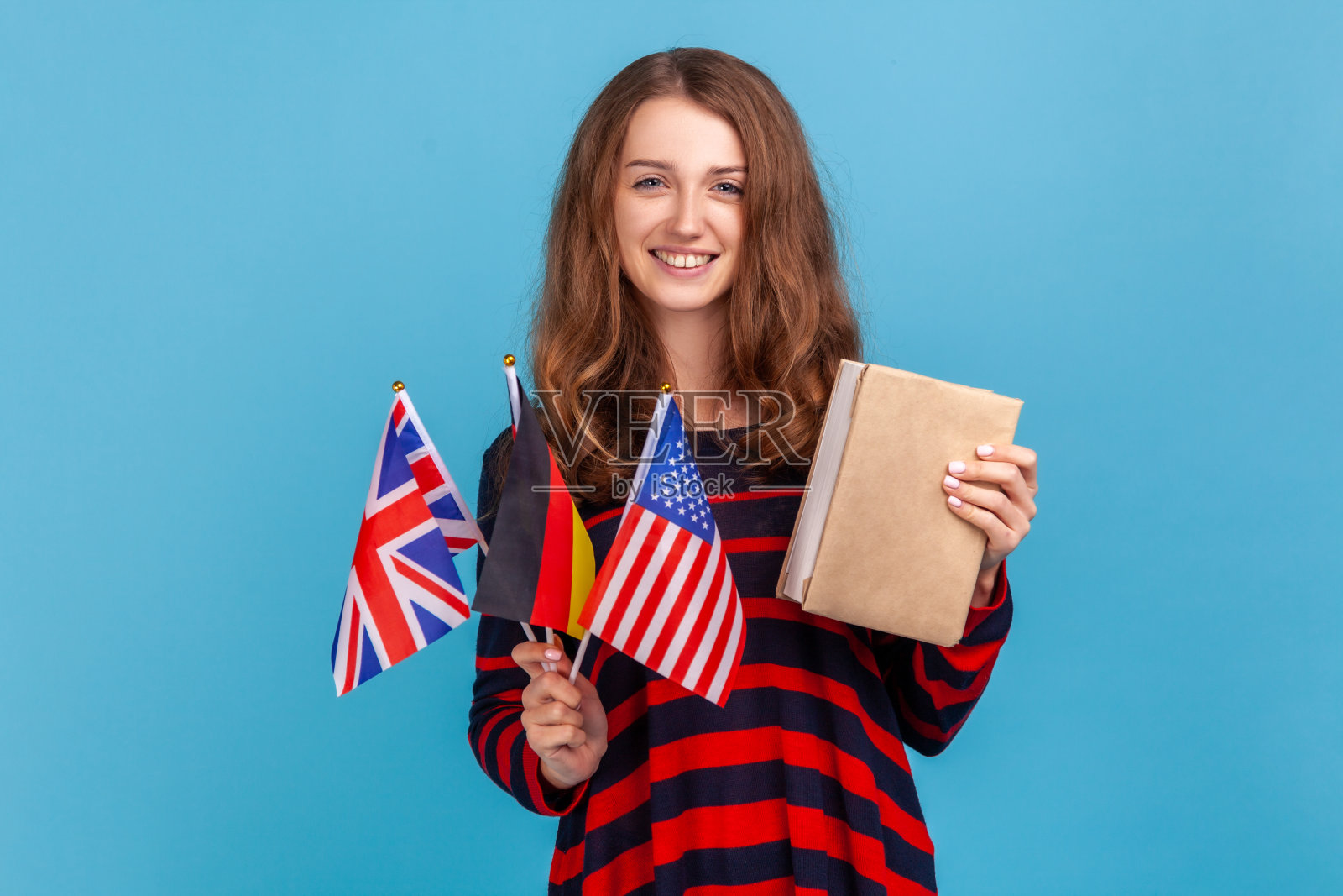 学生手持德国、美国、英国的图书旗，学习语言，出国留学。照片摄影图片