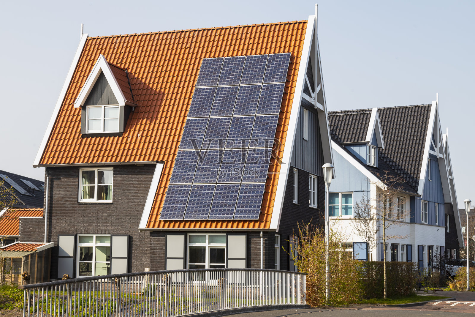 红色屋顶的新房子上安装了太阳能电池板。照片摄影图片