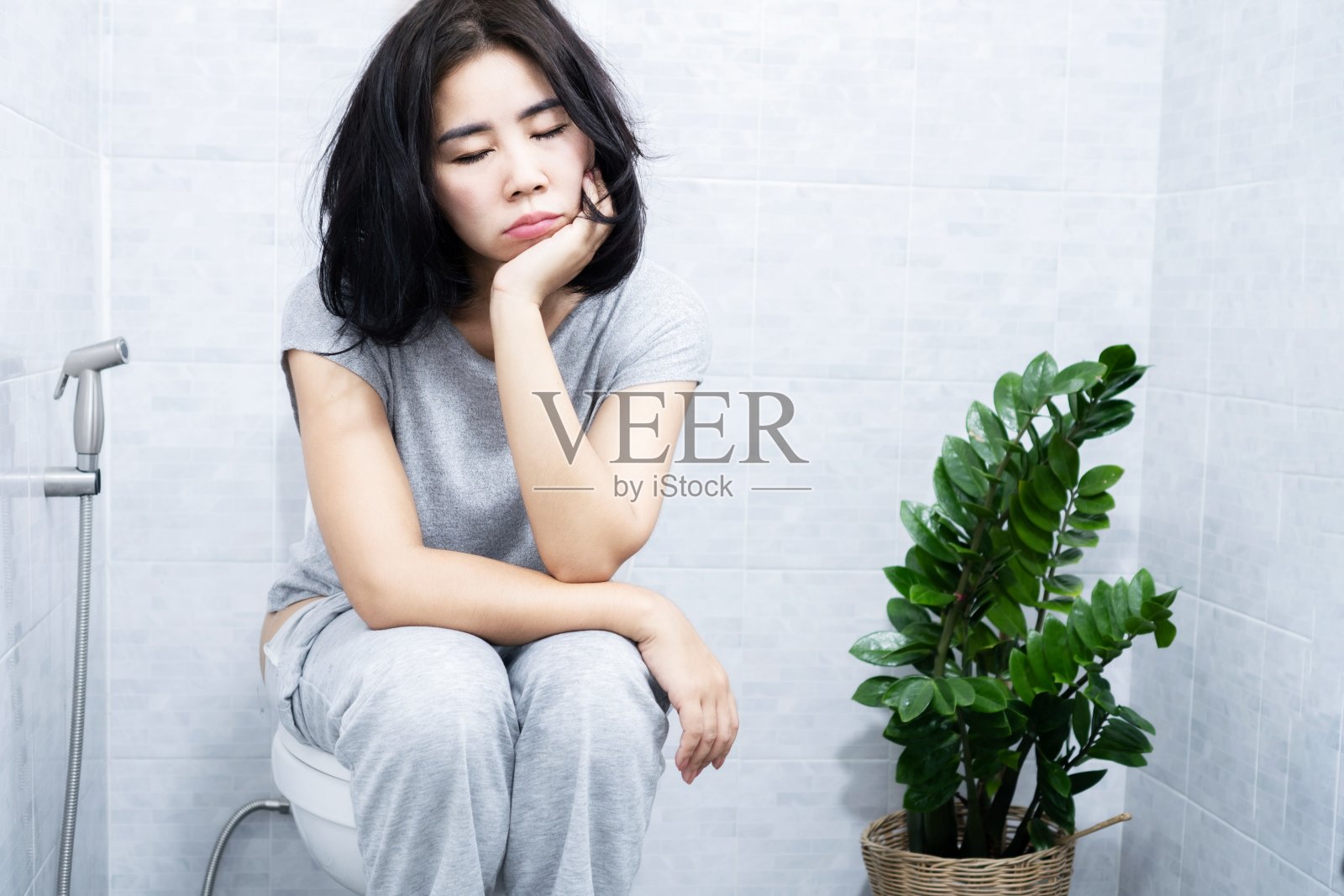 亚洲女性有嗜睡症的问题总觉得困，睡在洗手间里照片摄影图片