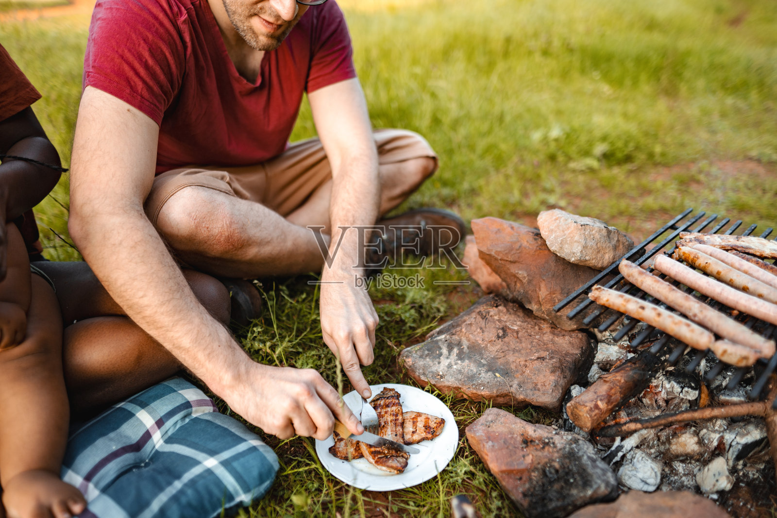幸福的家庭和小男孩在草地上烧烤野餐照片摄影图片