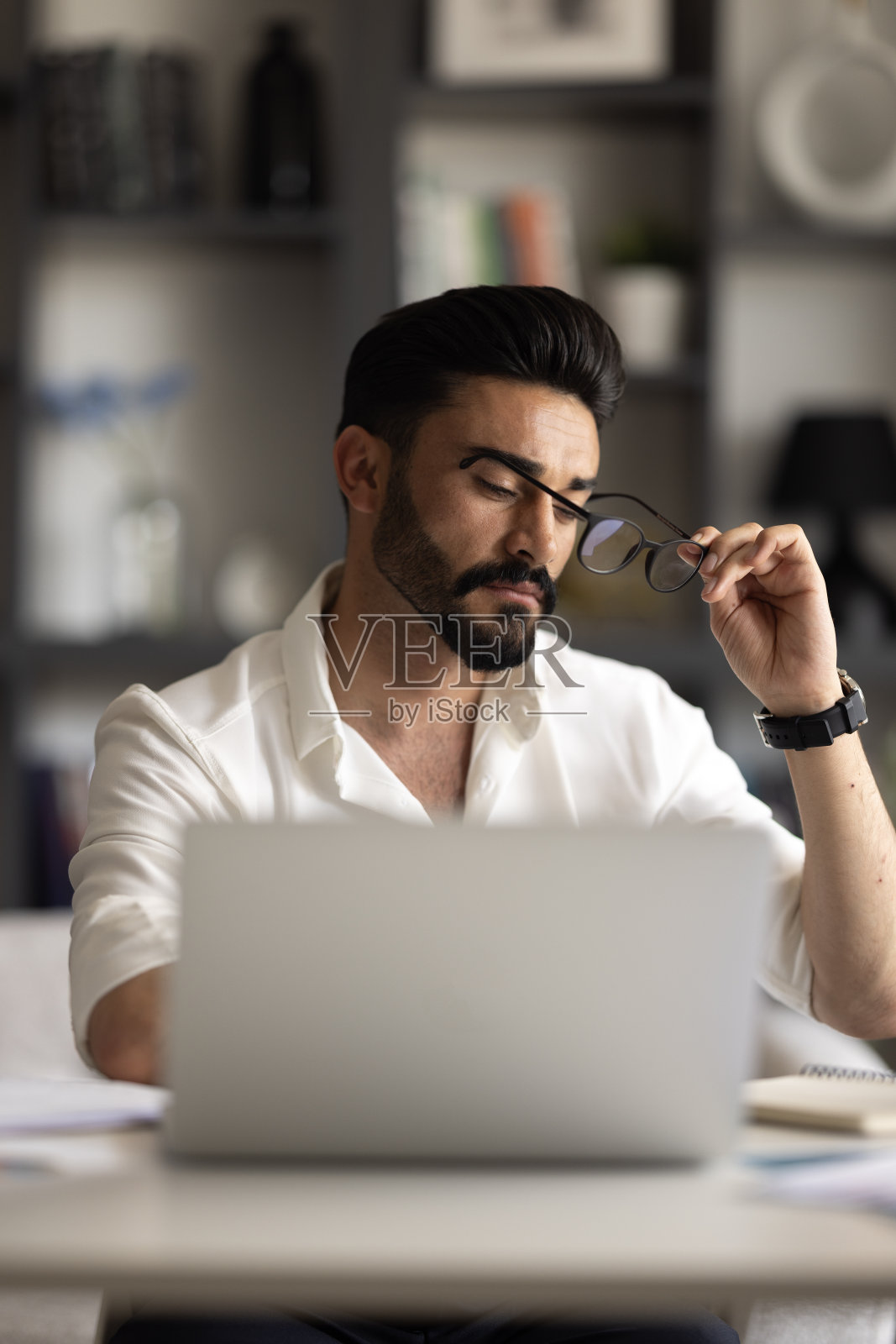 专注的商人坐在办公桌前用笔记本电脑工作照片摄影图片