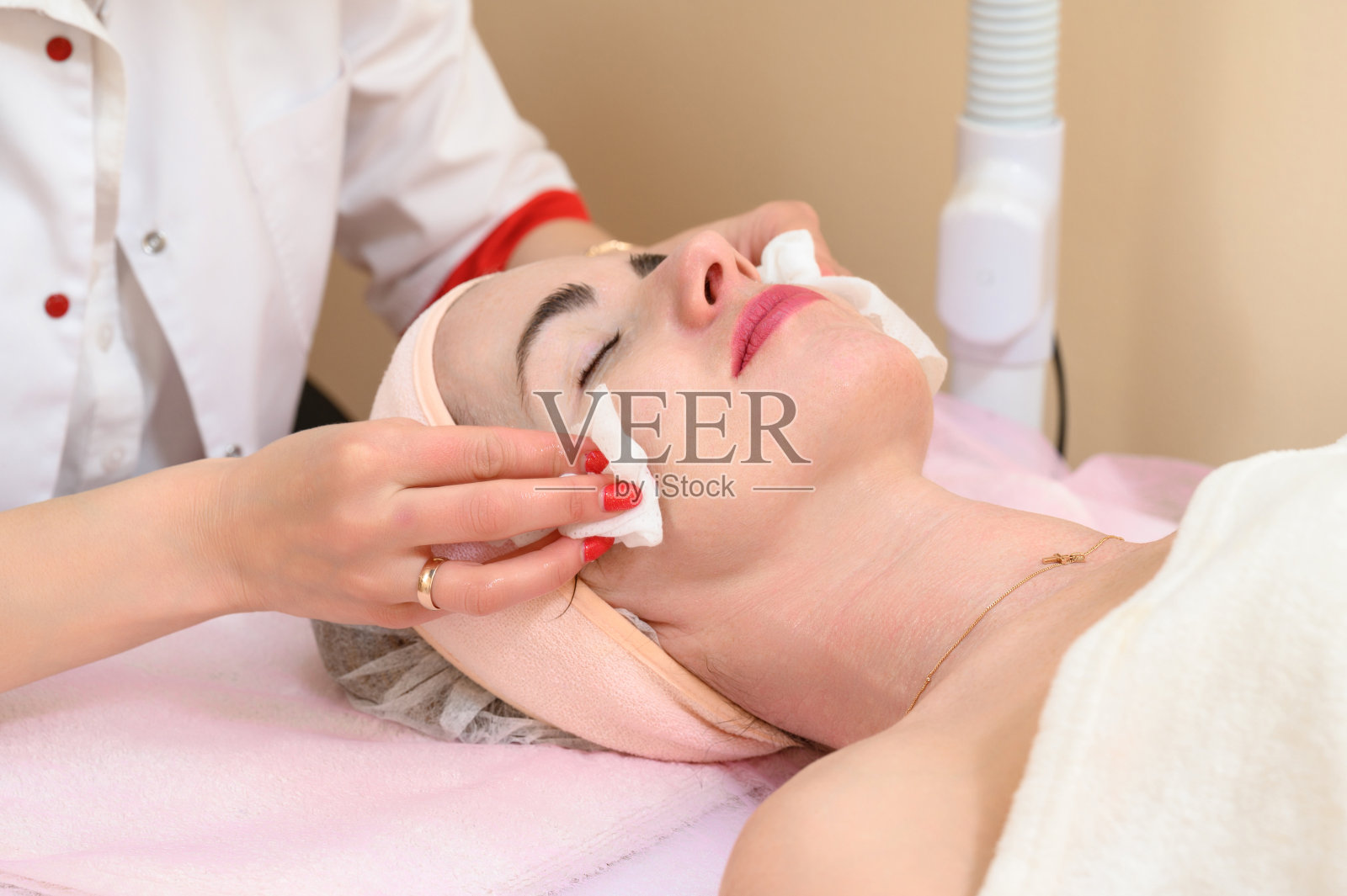 美容师正在擦拭女孩脸上残留的面霜照片摄影图片