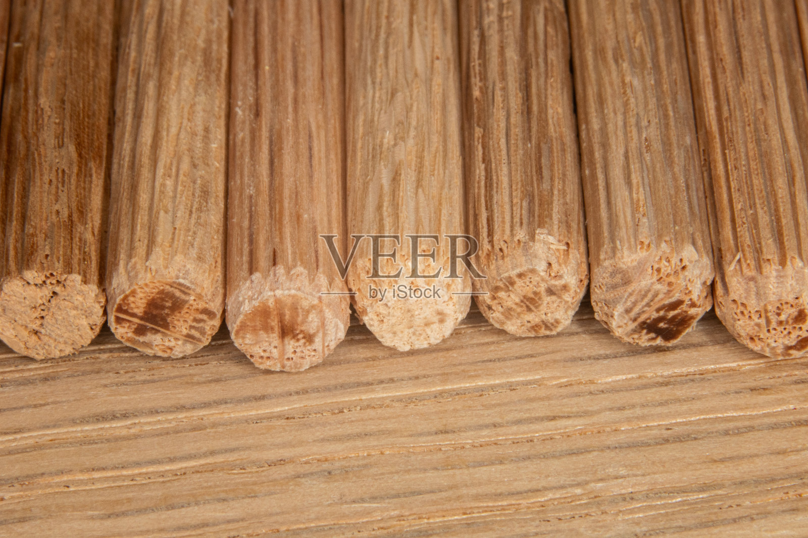 橡木背景上的一排橡木销子，销子用来连接两块木头，接头，细木工照片摄影图片