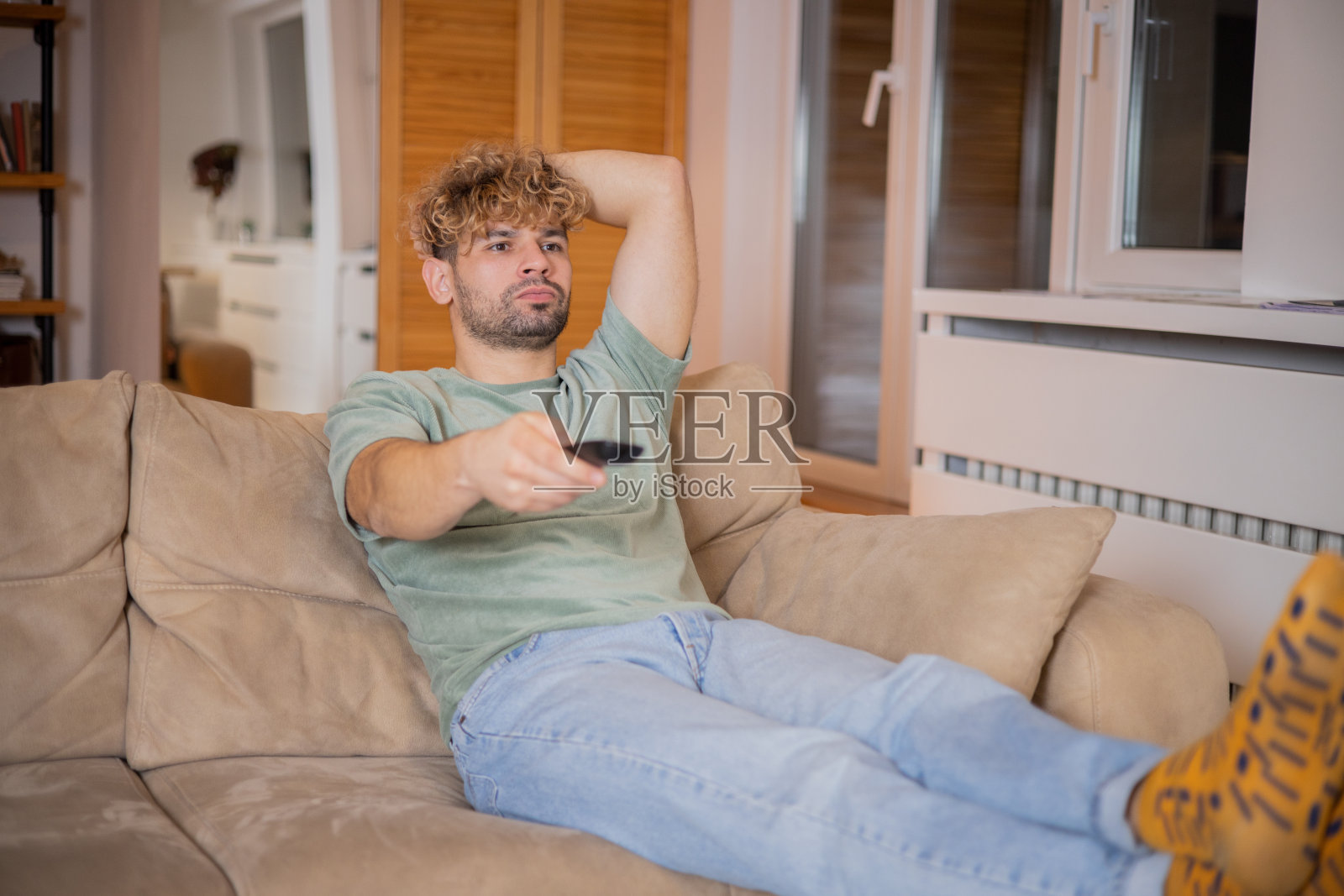 男人在家里享受他最喜欢的电视节目照片摄影图片