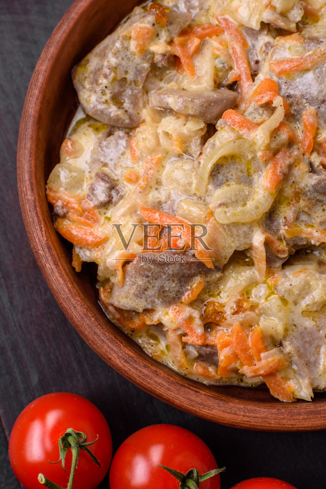 美味的煮牛肉或猪舌片，配以胡萝卜、洋葱、酸奶油和香料照片摄影图片