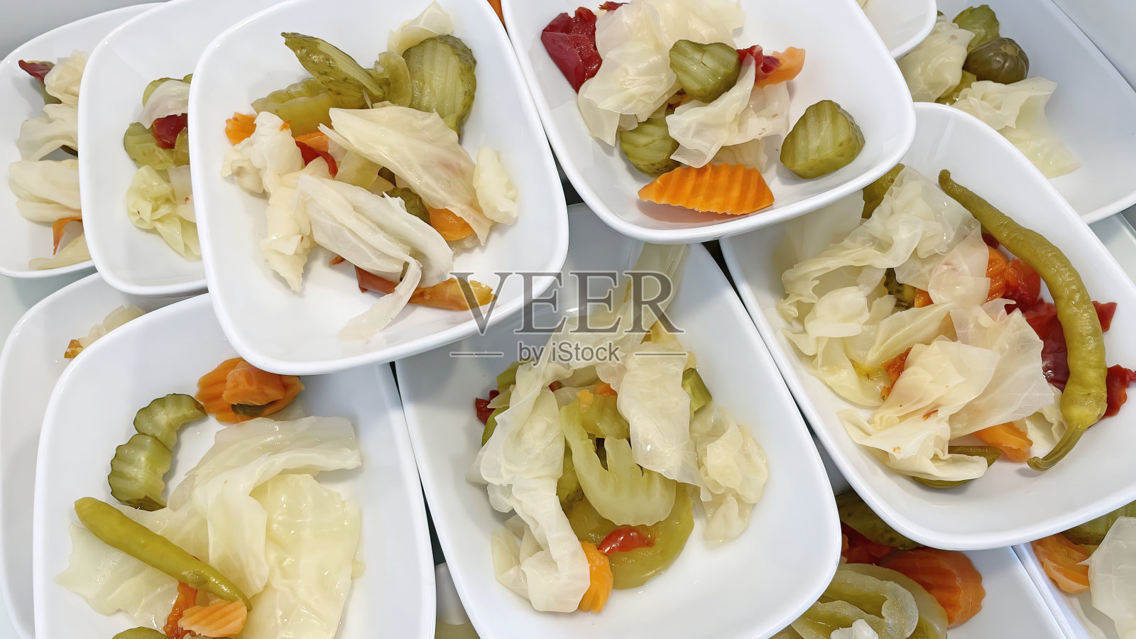 接近准备吃混合蔬菜泡菜在餐厅的白色盘子。照片摄影图片