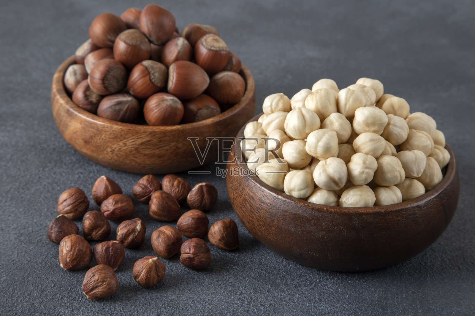 黑色背景上的一堆去皮和去壳的榛子照片摄影图片