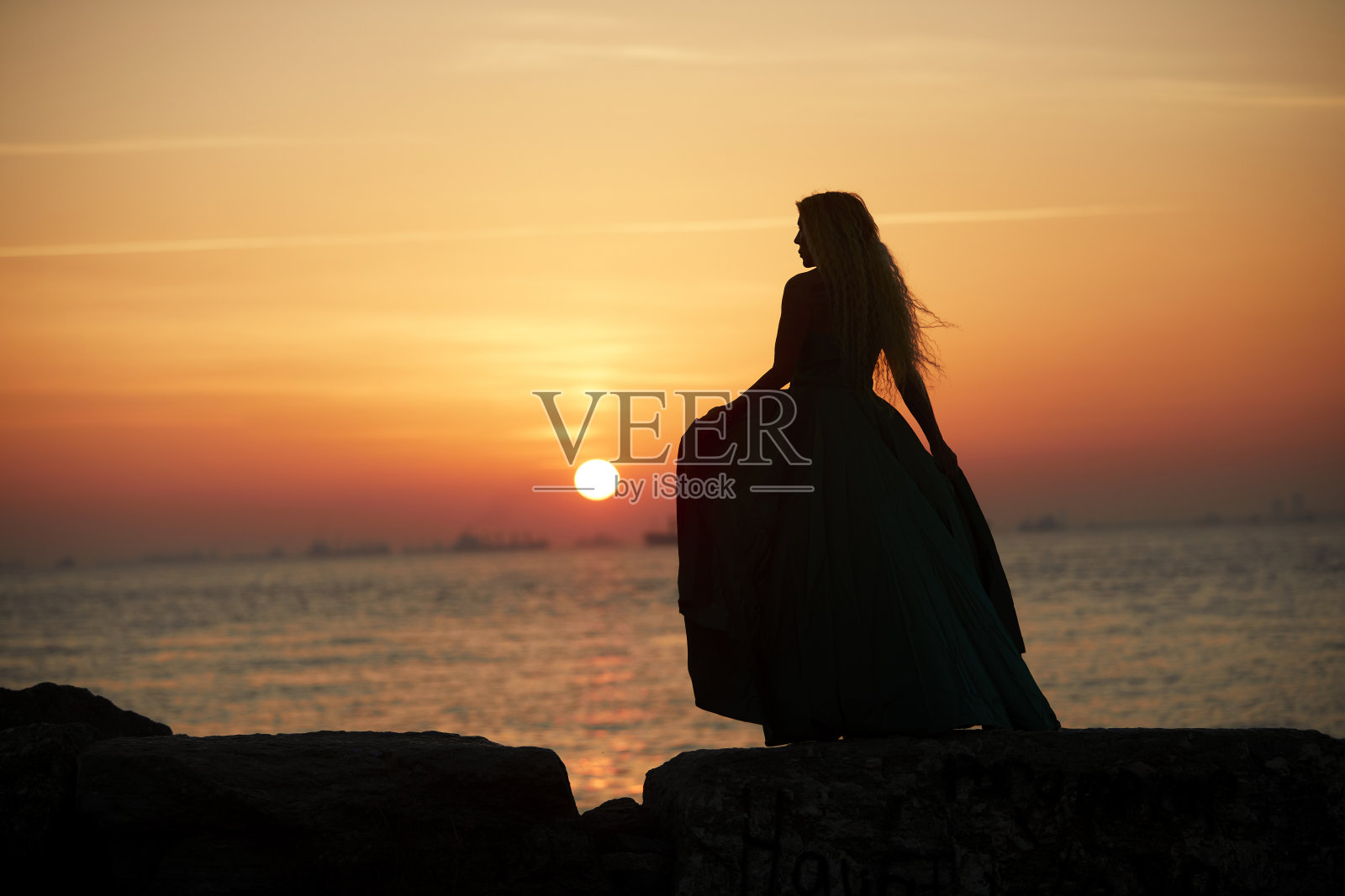 夕阳下的女子剪影照片摄影图片