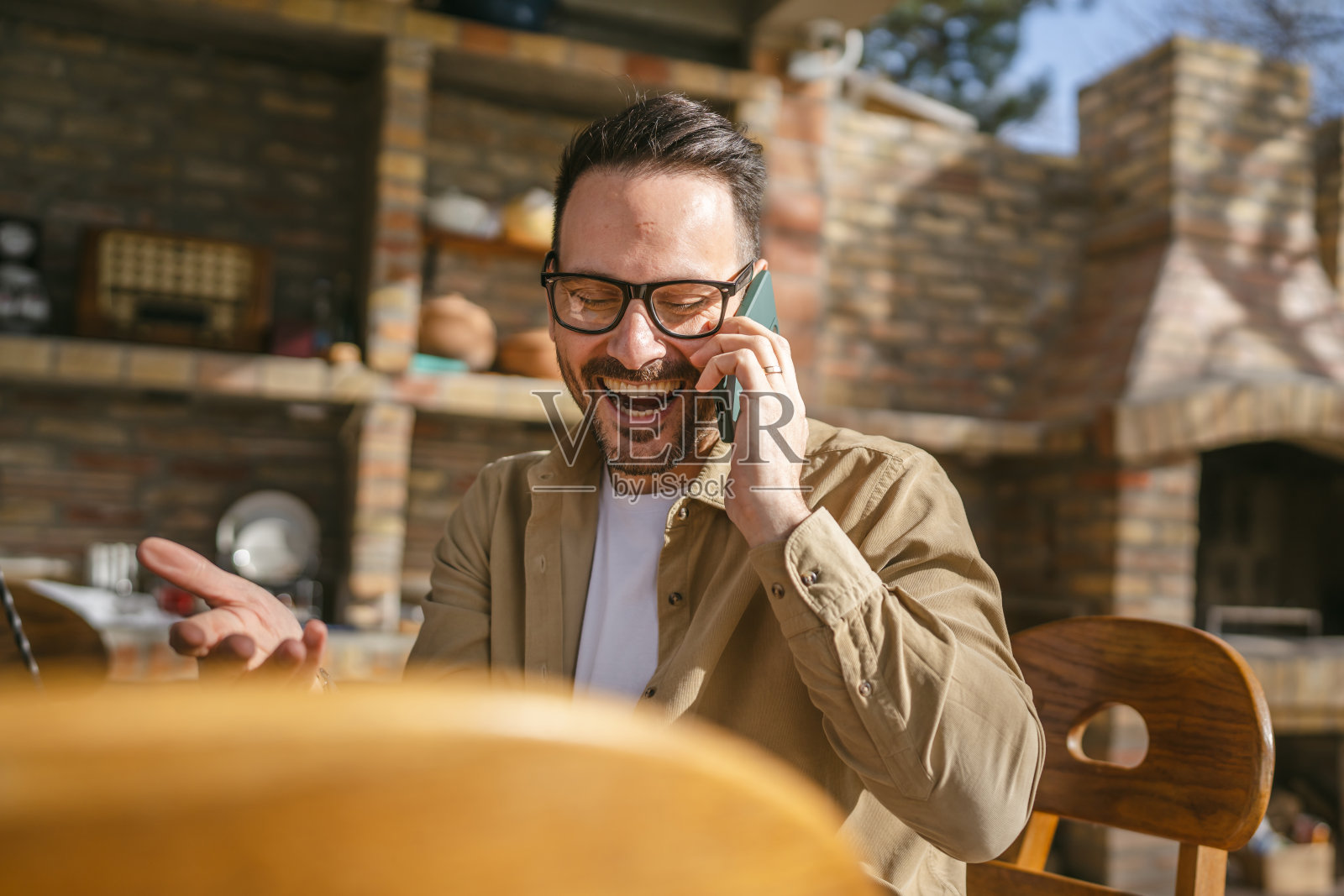 一天，一名成年男子在前房用智能手机打电话照片摄影图片