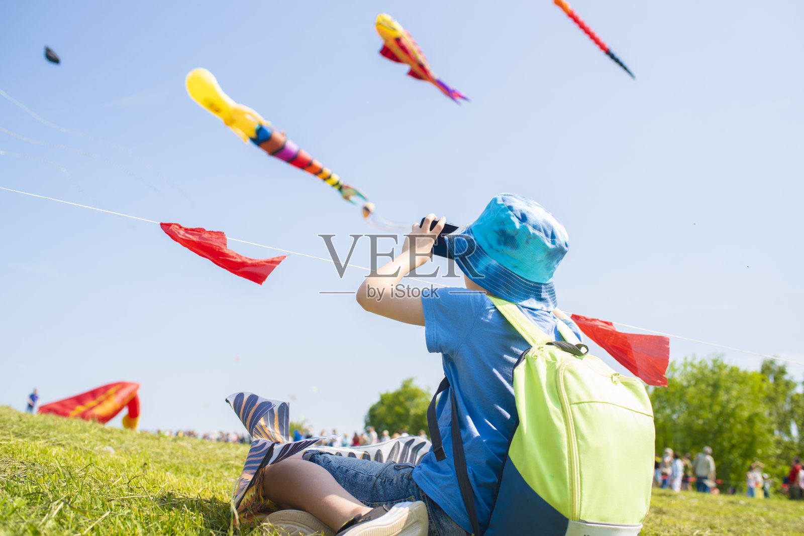 一个孩子在大风筝节上用手机拍照和录像照片摄影图片