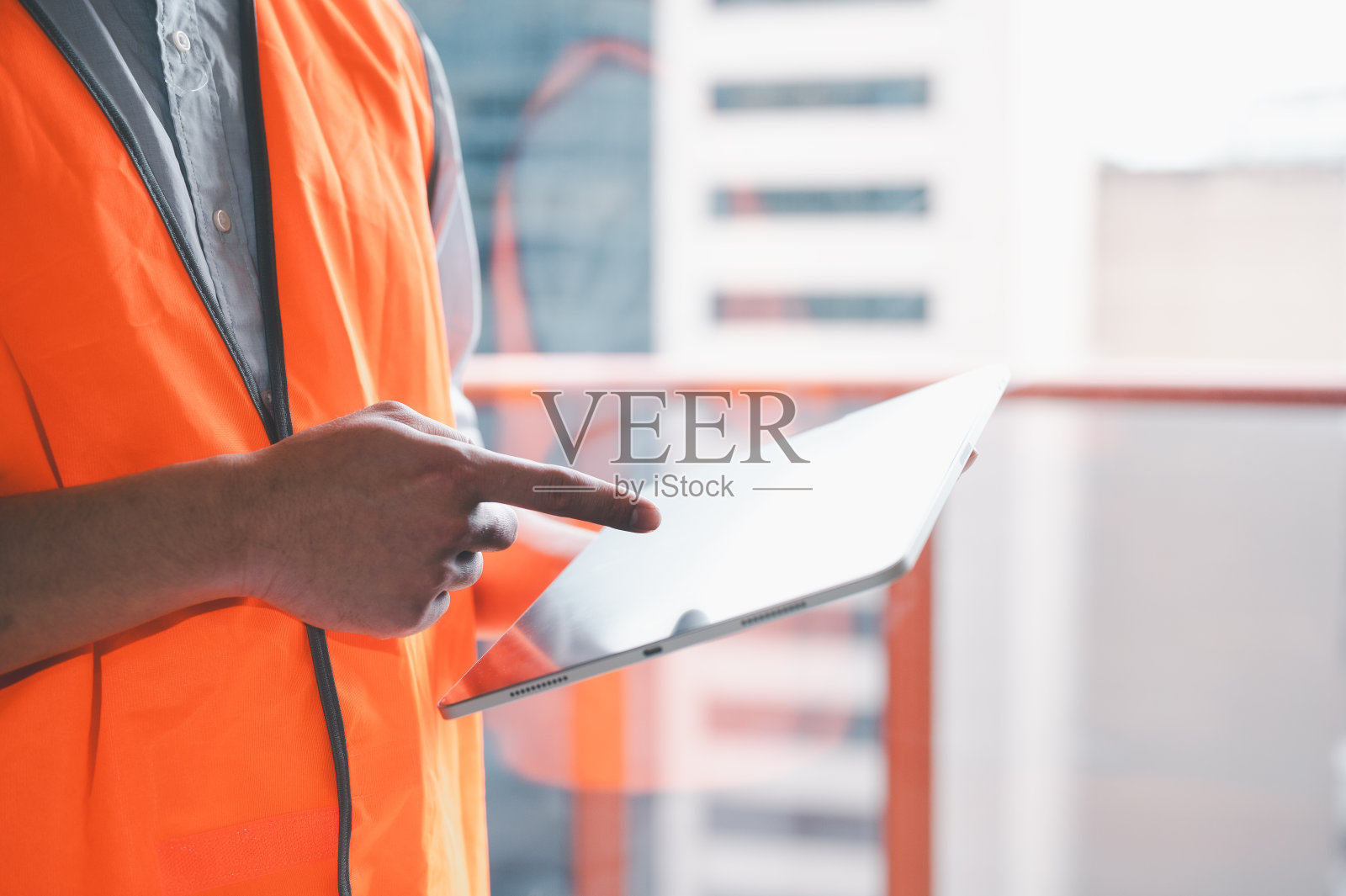 工人，领班或建筑工人穿着背心或安全衬衫和抱垫照片摄影图片