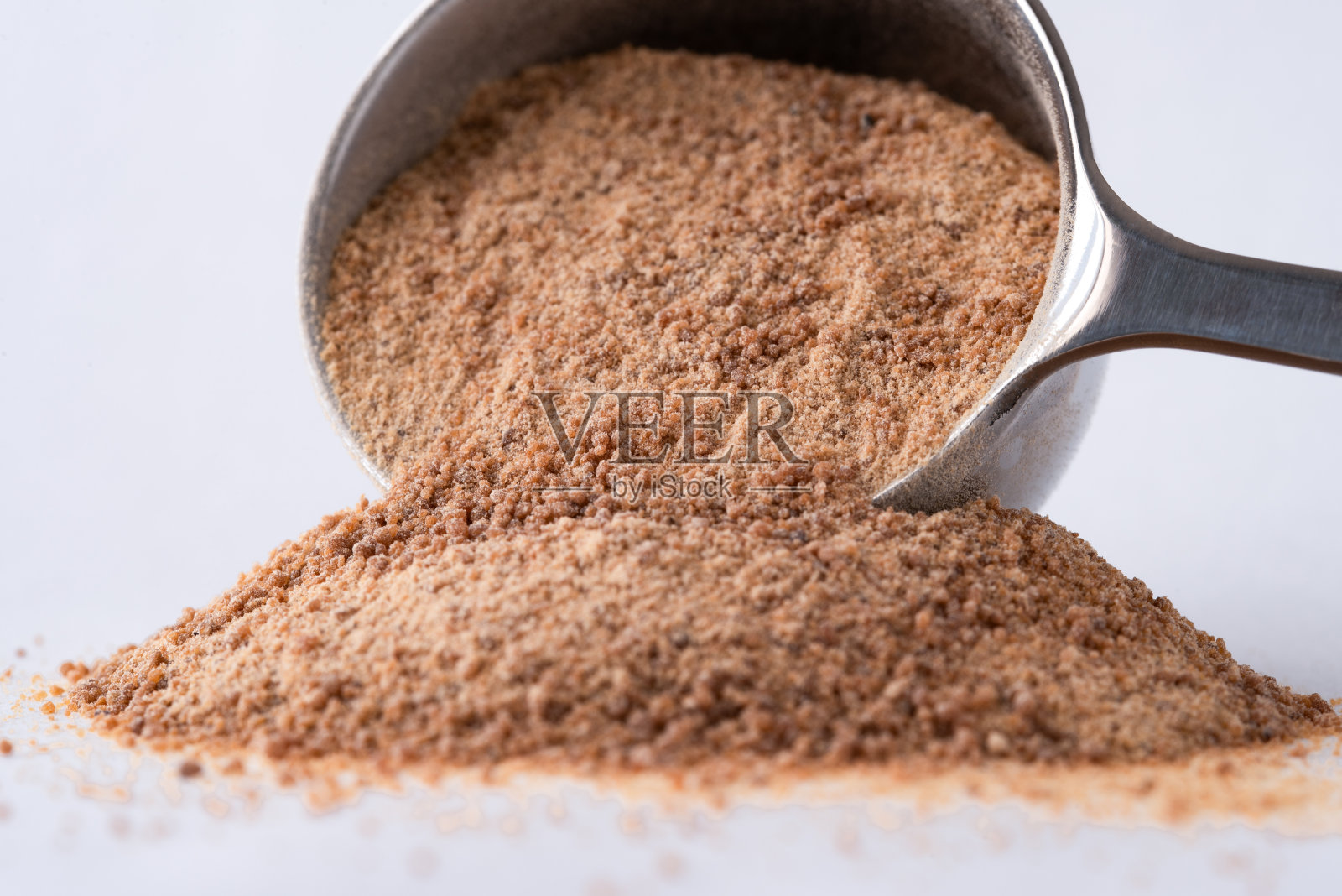 椰子糖从勺子里洒出来照片摄影图片