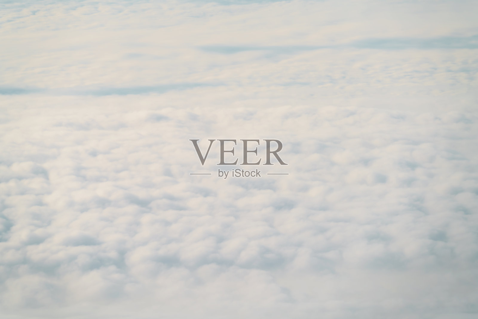 白天在云层上飞行的飞机的航拍照片照片摄影图片