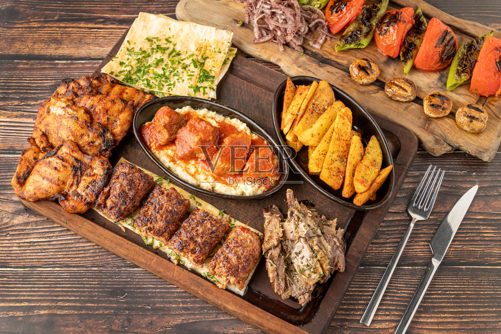 混合土耳其烤架，包括阿达纳烤肉串，烤鸡和烤羊肉在木桌上照片摄影图片