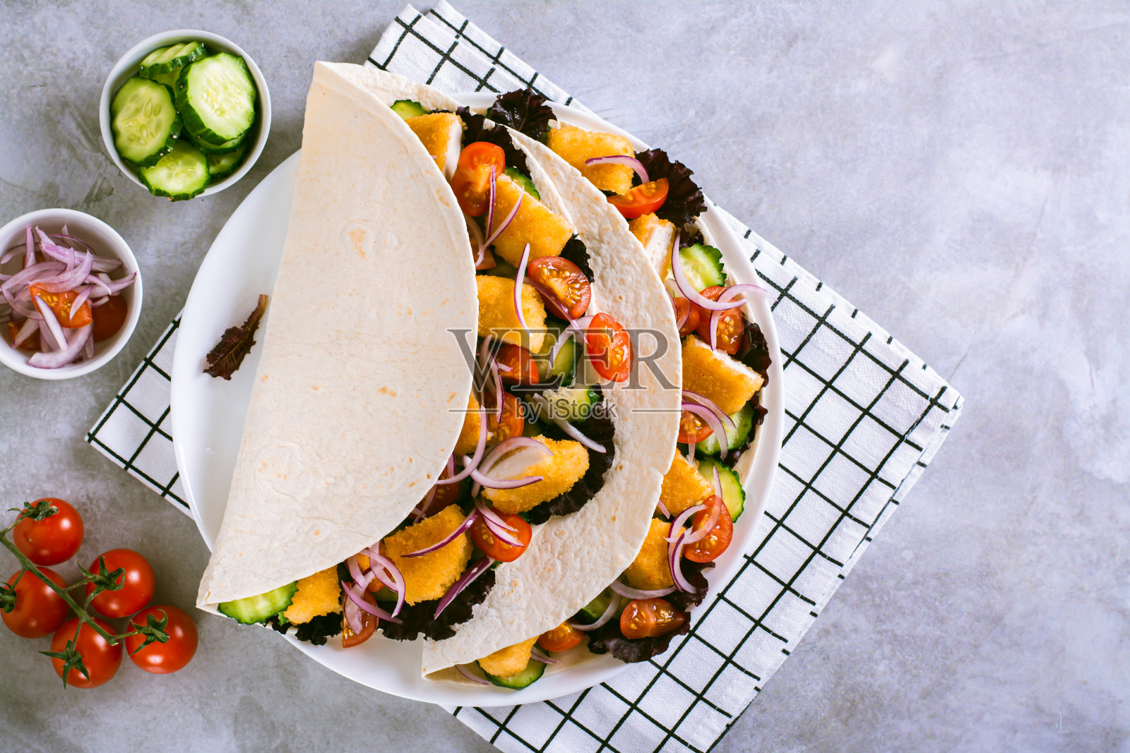 玉米饼上有鸡块、蔬菜、洋葱和生菜照片摄影图片