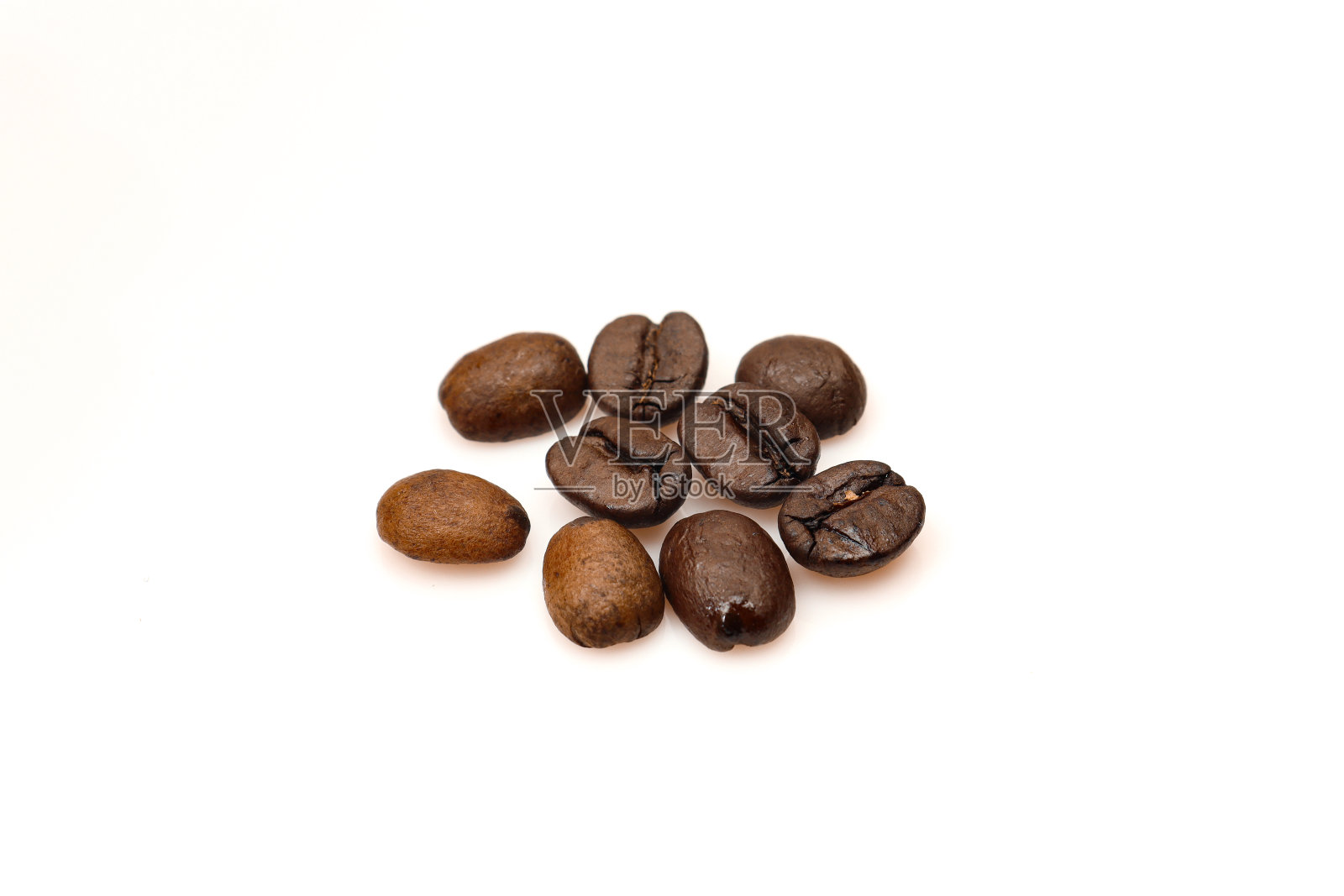 很少有烤过的咖啡豆孤立在白色的背景上照片摄影图片