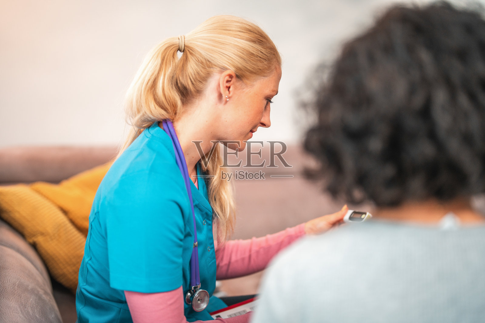 女医生在病人家中阅读脉搏血氧计读数照片摄影图片