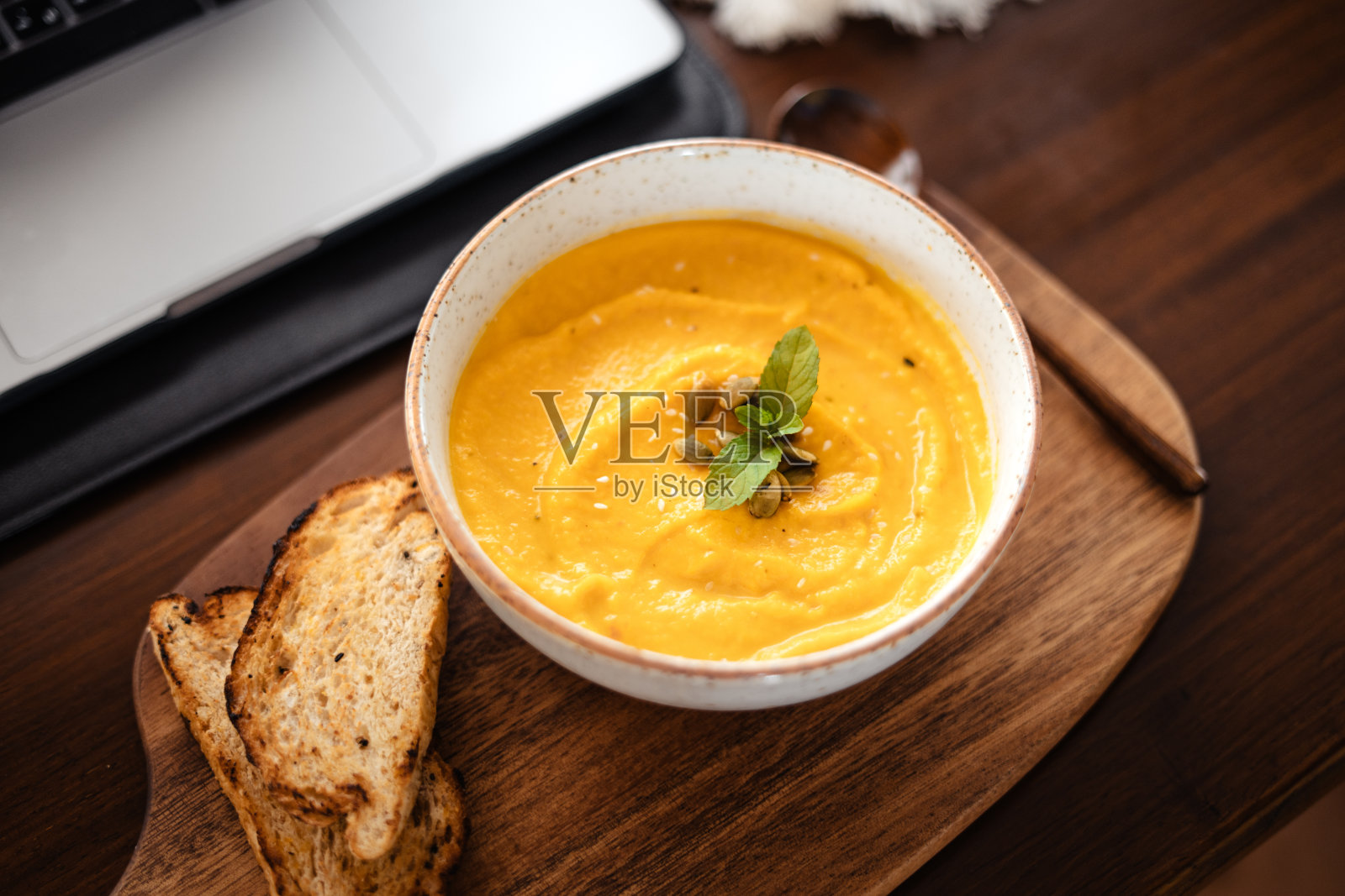 南瓜奶油汤配南瓜子和面包丁。照片摄影图片