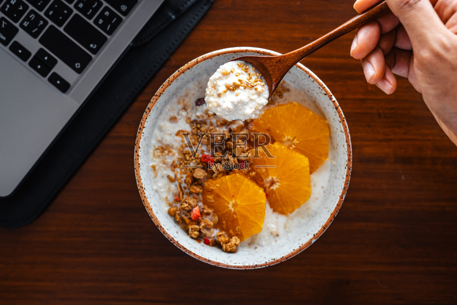 桌上的早餐有燕麦，橘子和格兰诺拉麦片。照片摄影图片