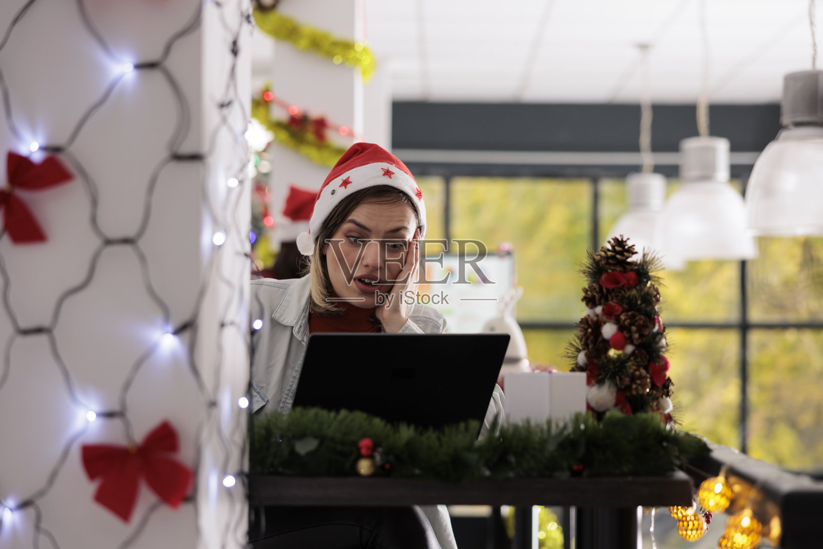 震惊的员工戴着圣诞帽照片摄影图片