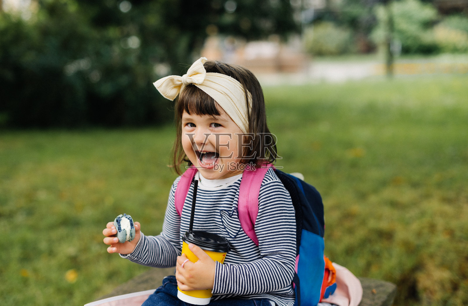 有趣的女孩喝可可，吃马卡龙照片摄影图片