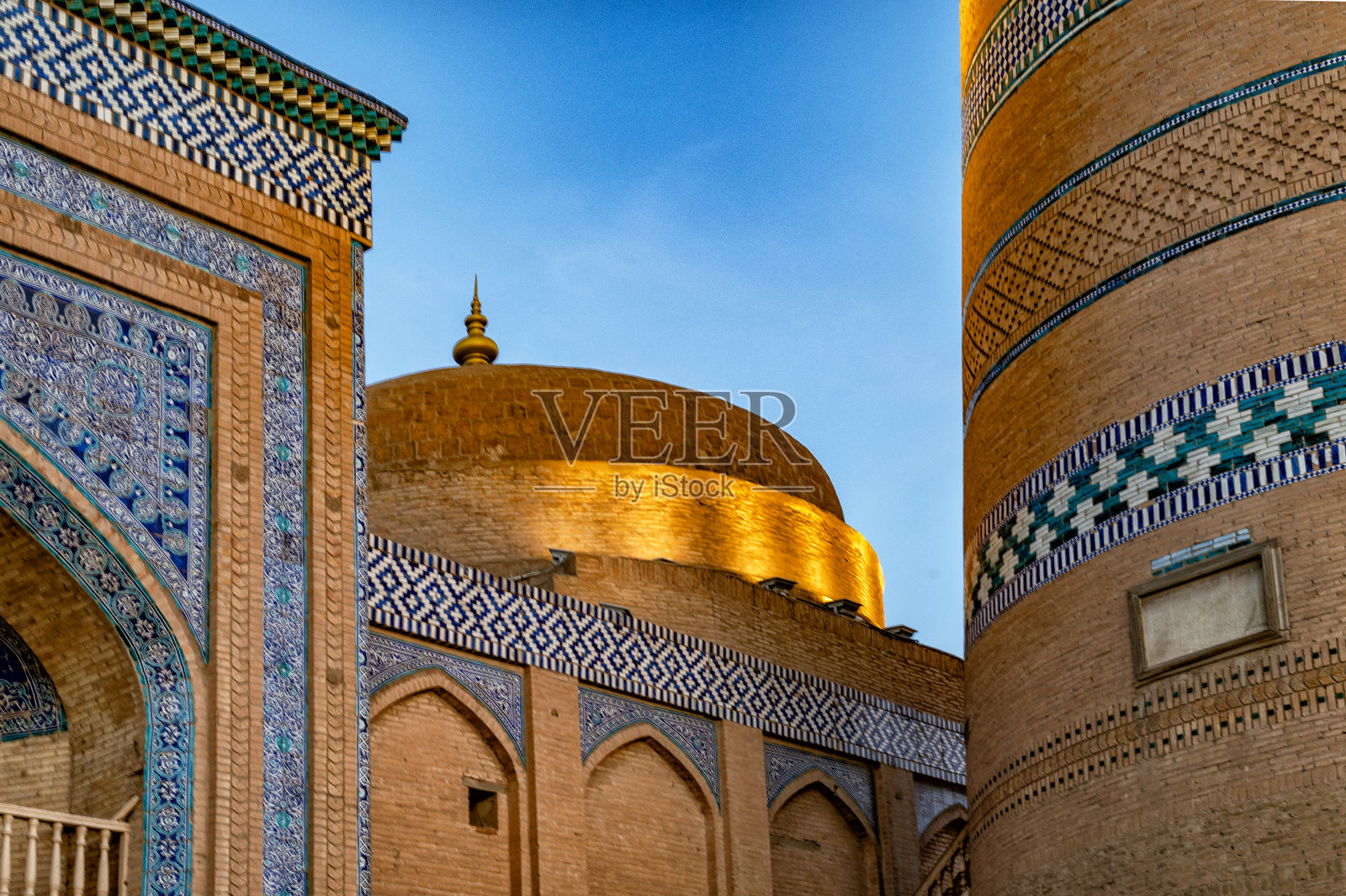 日落时分，乌兹别克斯坦Khiiva的马德拉斯圆顶。照片摄影图片