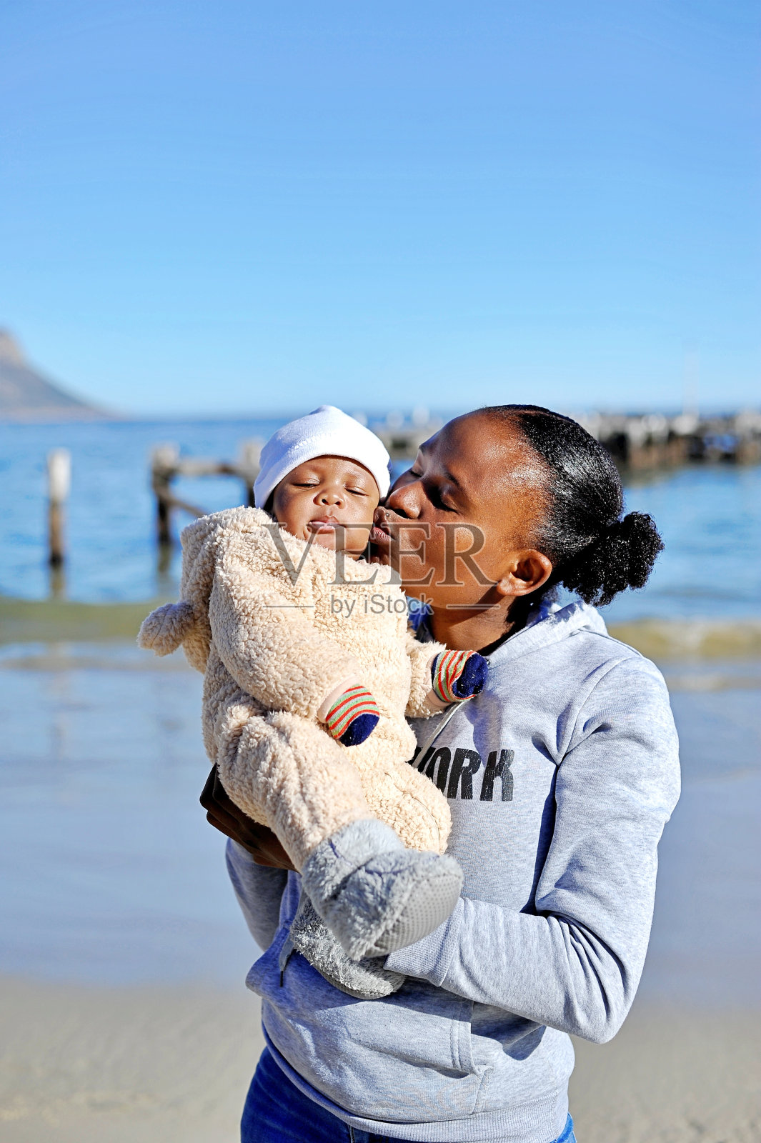 一个非洲黑人妇女在沙滩上和她的孩子玩耍照片摄影图片