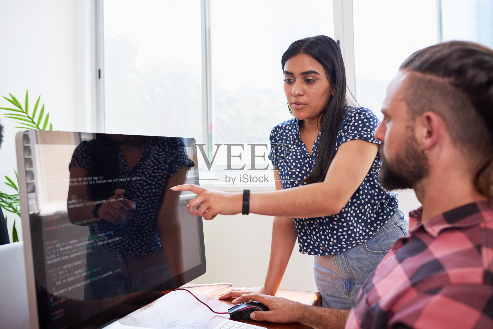 两名开发人员在办公室同行编程，协助同行评审照片摄影图片