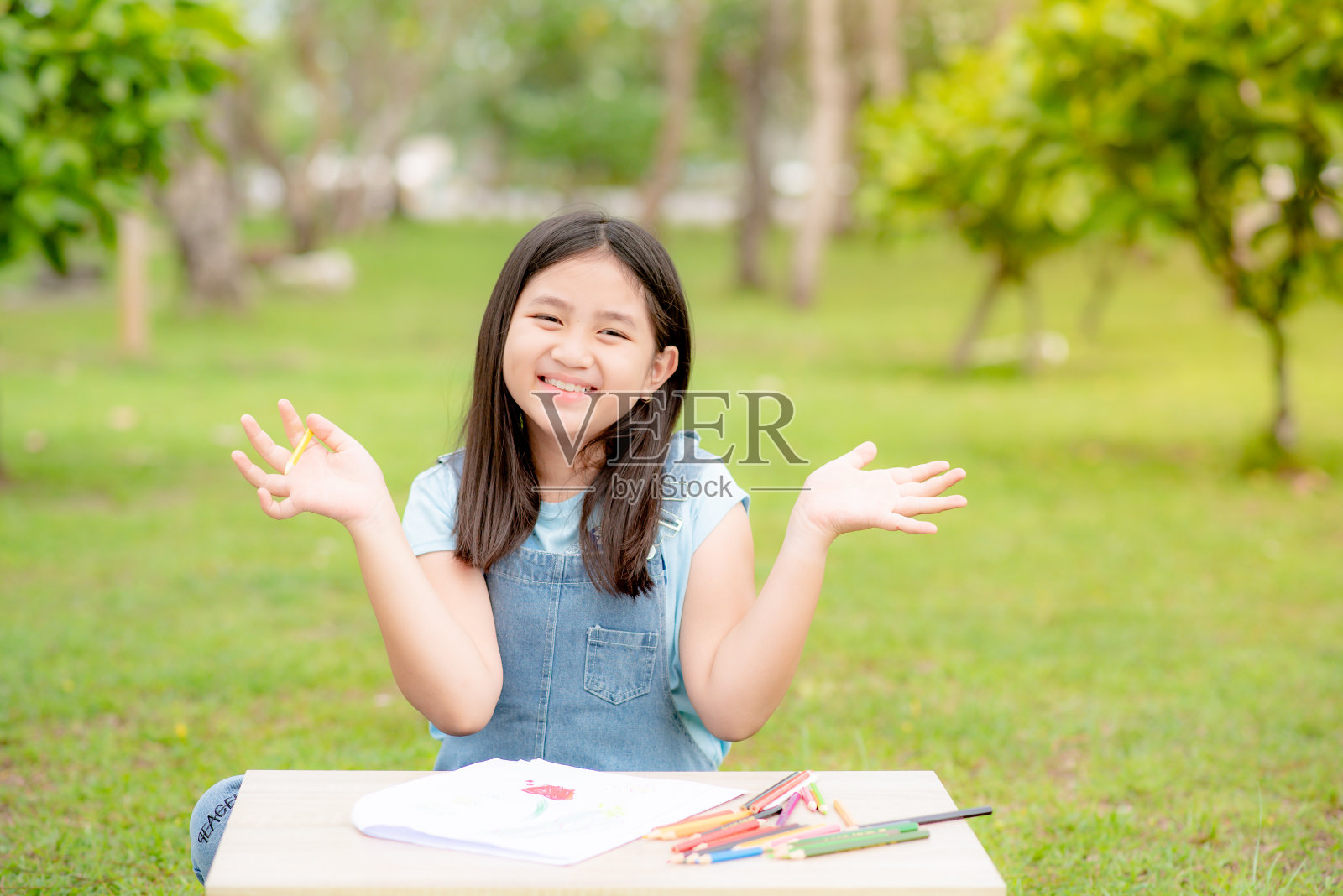 她坐在屋外的花园里。照片摄影图片