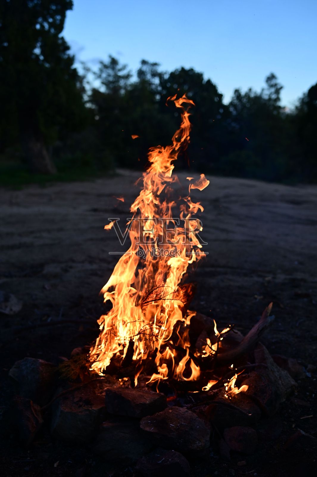 火焰从农村地区的一个大岩石堆下面发出橙色的光芒照片摄影图片