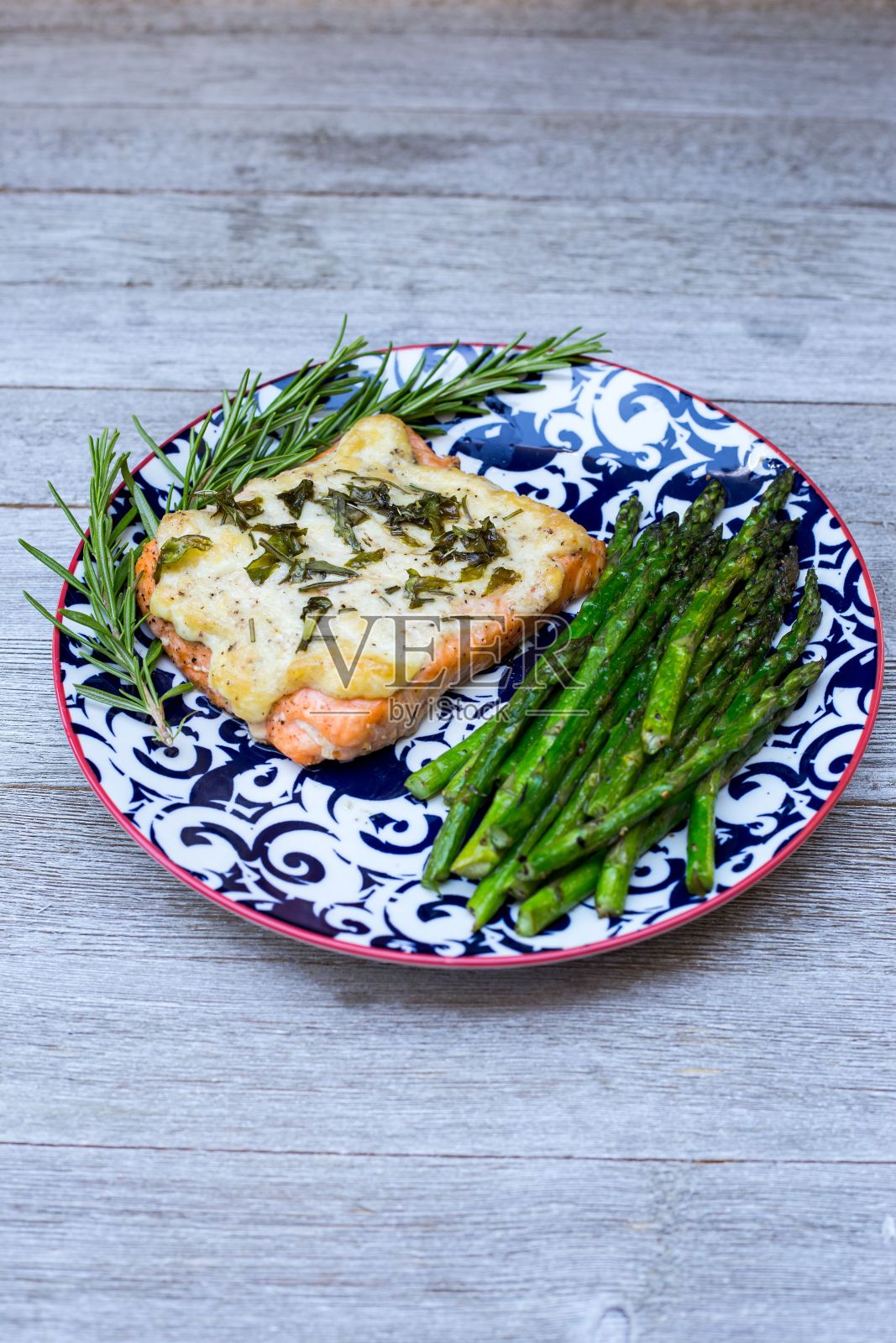 木桌上盛满鲑鱼和芦笋的盘子。照片摄影图片