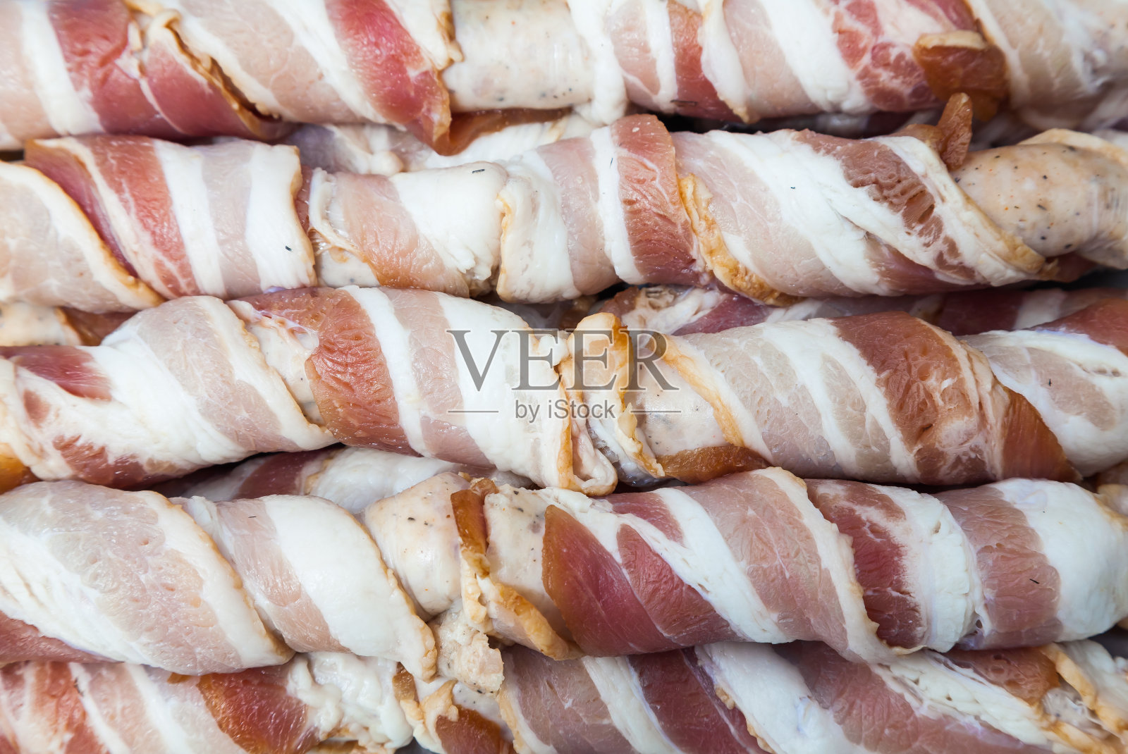 木盘上的猪肉培根卷照片摄影图片